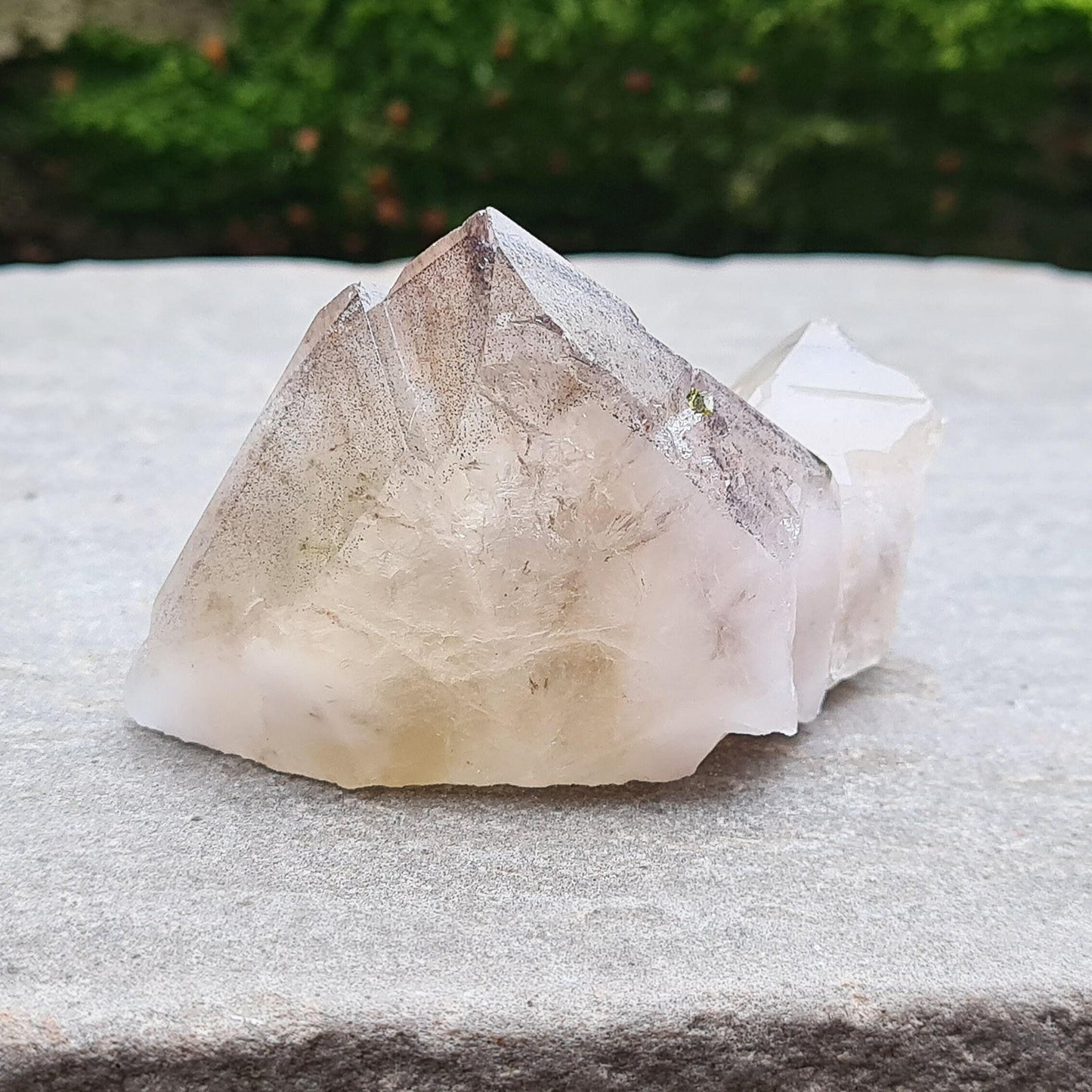 This beautiful Ametrine with Hematite Crystal Standing Point comes from China. A colour shines through in natural light, with a double polished tip, natural body, and a cut base. The addition of Hematite grounds Ametrine’s mental clarity and spiritual uplift, creating a deeply balancing and energising piece.