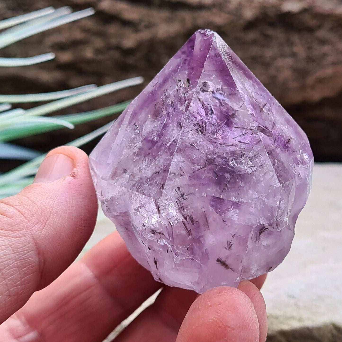 Amethyst Crystal Point with Goethite Inclusions. Beautiful purple color with black Goethite inclusions. Polished point with a natural body and cut base.