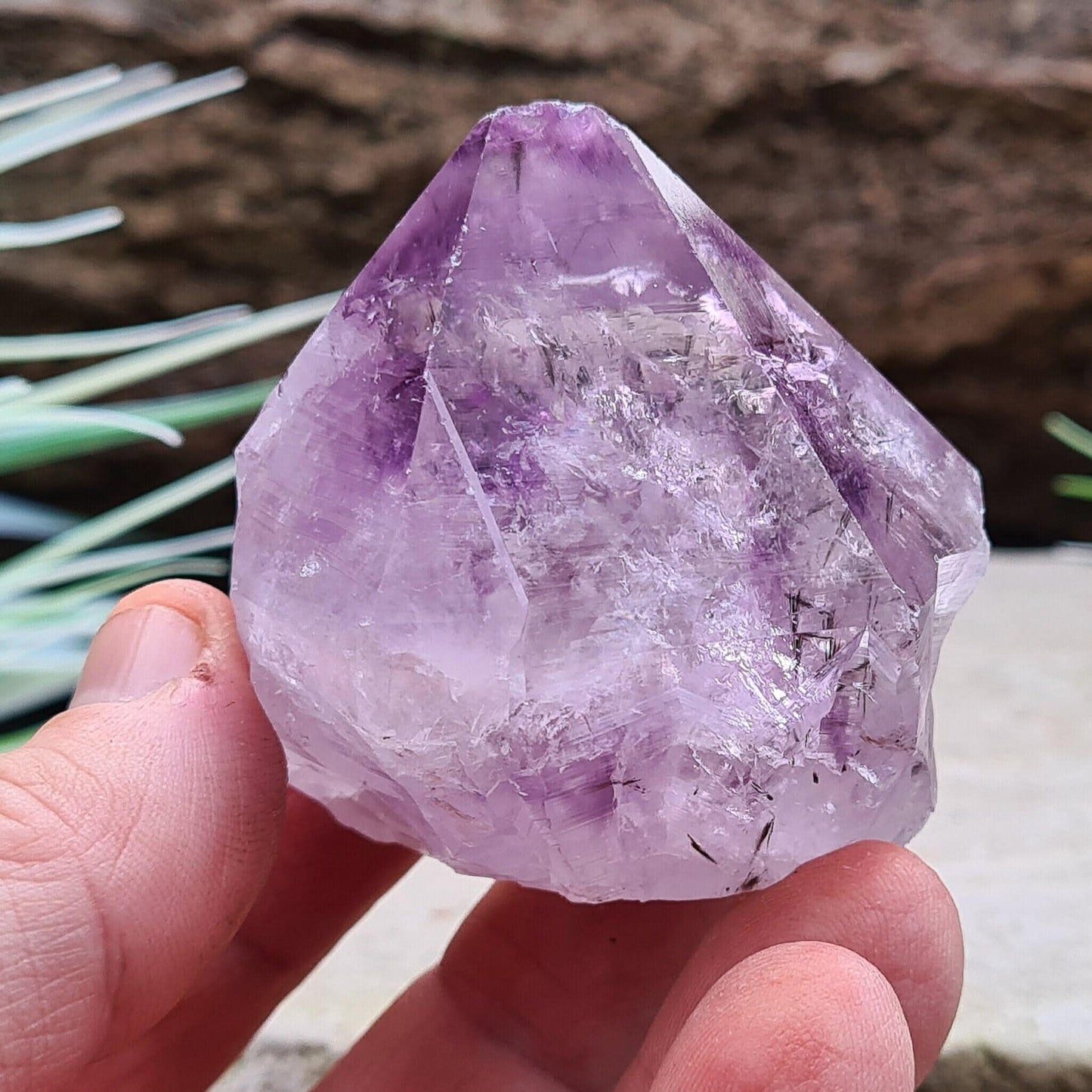 Amethyst Crystal Point with Goethite Inclusions. Beautiful purple color with black Goethite inclusions. Polished point with a natural body and cut base.