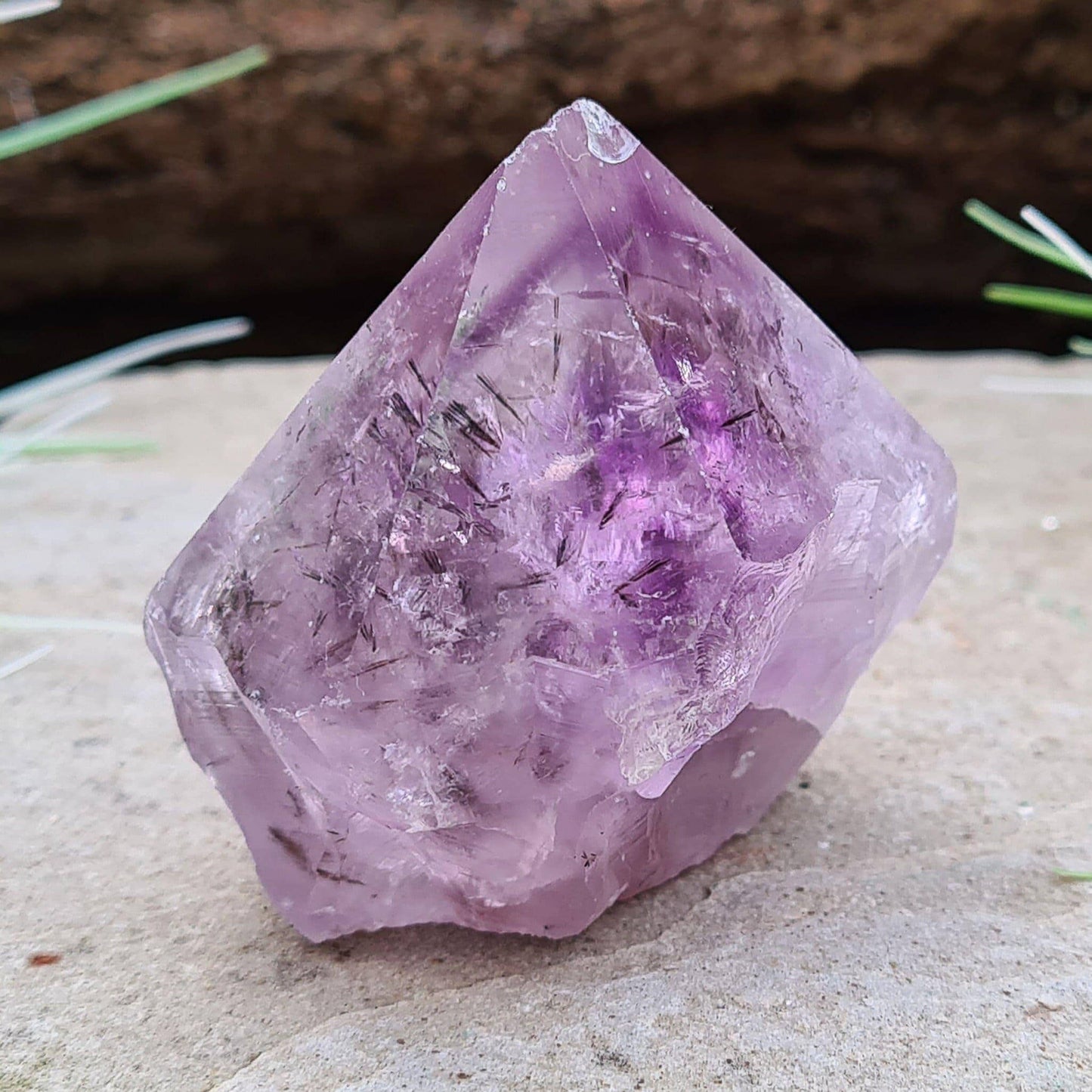 Amethyst Crystal Point with Goethite Inclusions. Beautiful purple color with black Goethite inclusions. Polished point with a natural body and cut base.