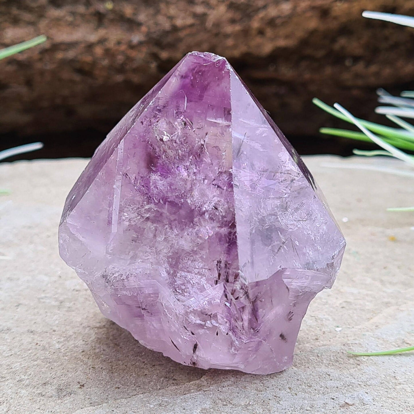 Amethyst Crystal Point with Goethite Inclusions. Beautiful purple color with black Goethite inclusions. Polished point with a natural body and cut base.