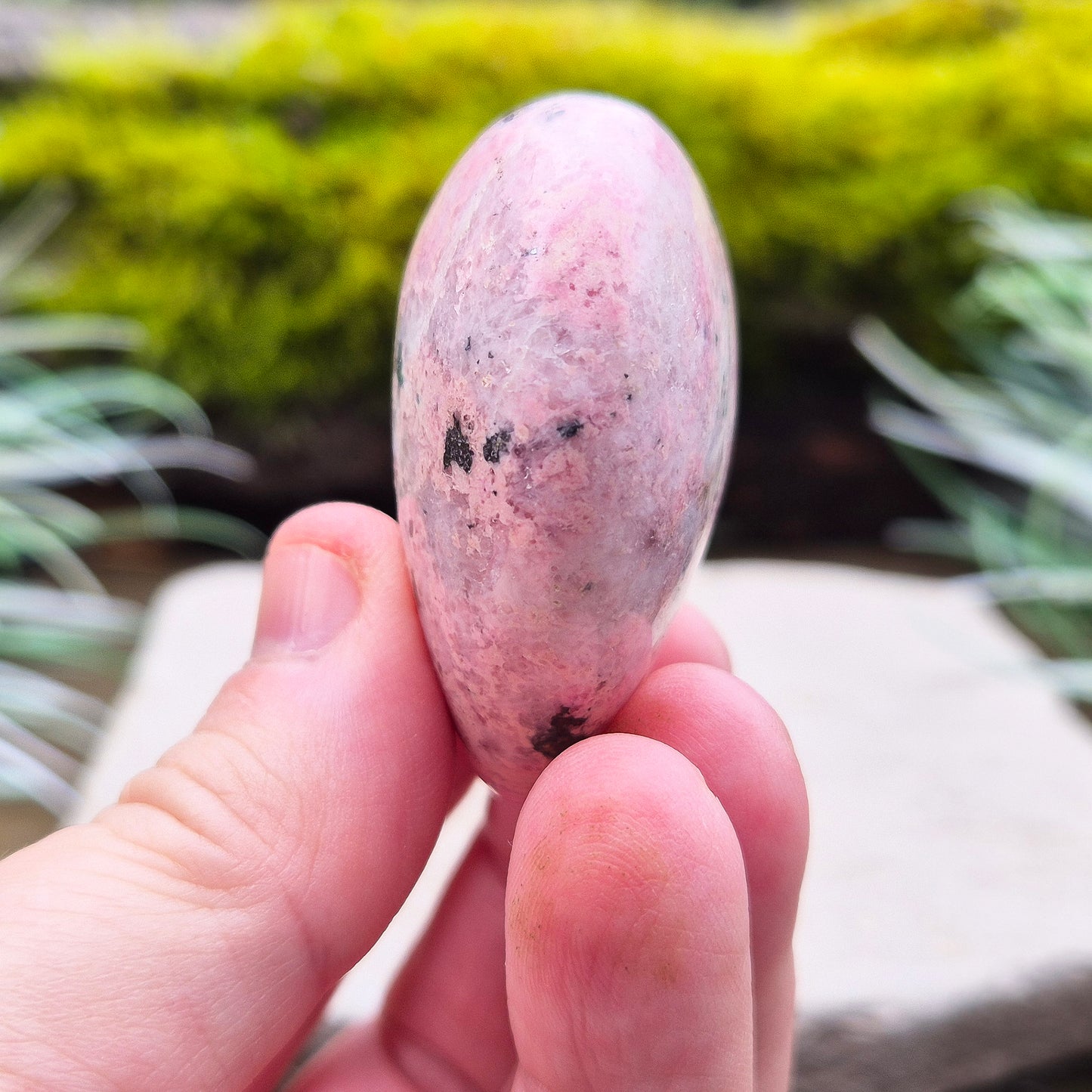 Pink Rhodonite Crystal Heart – also known as Bubblegum Pink Rhodonite from Peru. This beautiful heart-shaped Rhodonite crystal, sometimes nicknamed Bubblegum Pink Rhodonite, comes from Peru and features a soft pink colour with black patches caused by the natural oxidation of manganese.