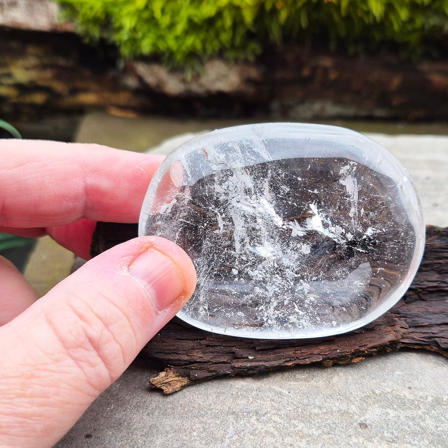 This beautifully polished Clear Quartz palm stone fits comfortably in the hand. Has light reflecting inclusions within it which catch the light.