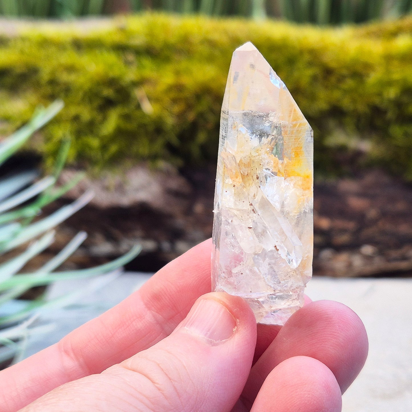 This rare Blade of Light Quartz is a striking Lemurian Quartz from the mountains of Colombia. Known for its exceptional clarity and natural brilliance, this piece features a point that has a few smaller crystals growing out of/into it.
