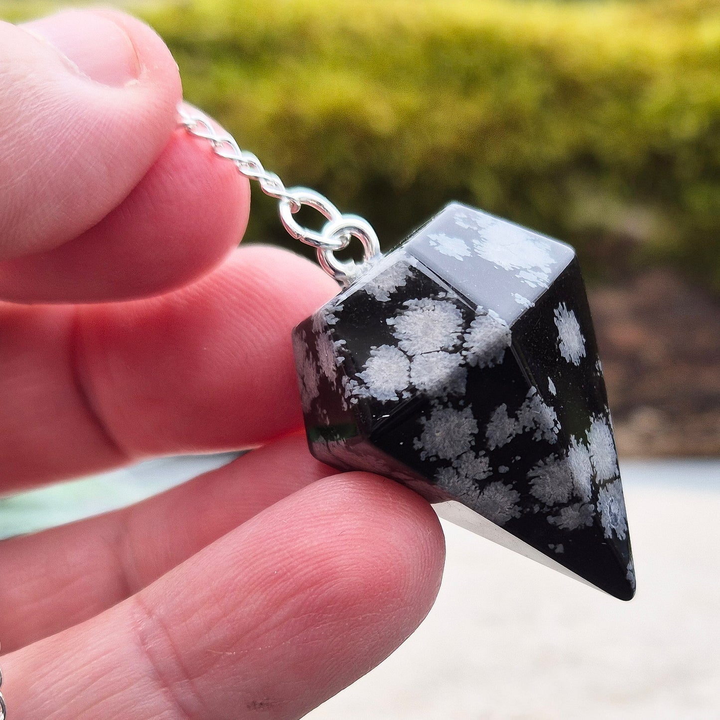 Snowflake Obsidian Crystal Pendulum from the USA. Comes in a organza pouch to keep it in. Chain has a metal ring at the end of it.