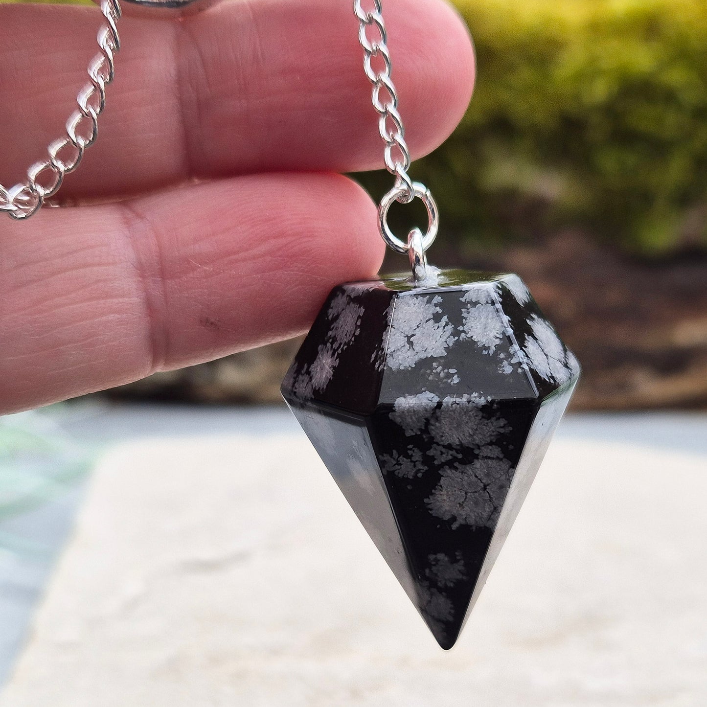 Snowflake Obsidian Crystal Pendulum from the USA. Comes in a organza pouch to keep it in. Chain has a metal ring at the end of it.