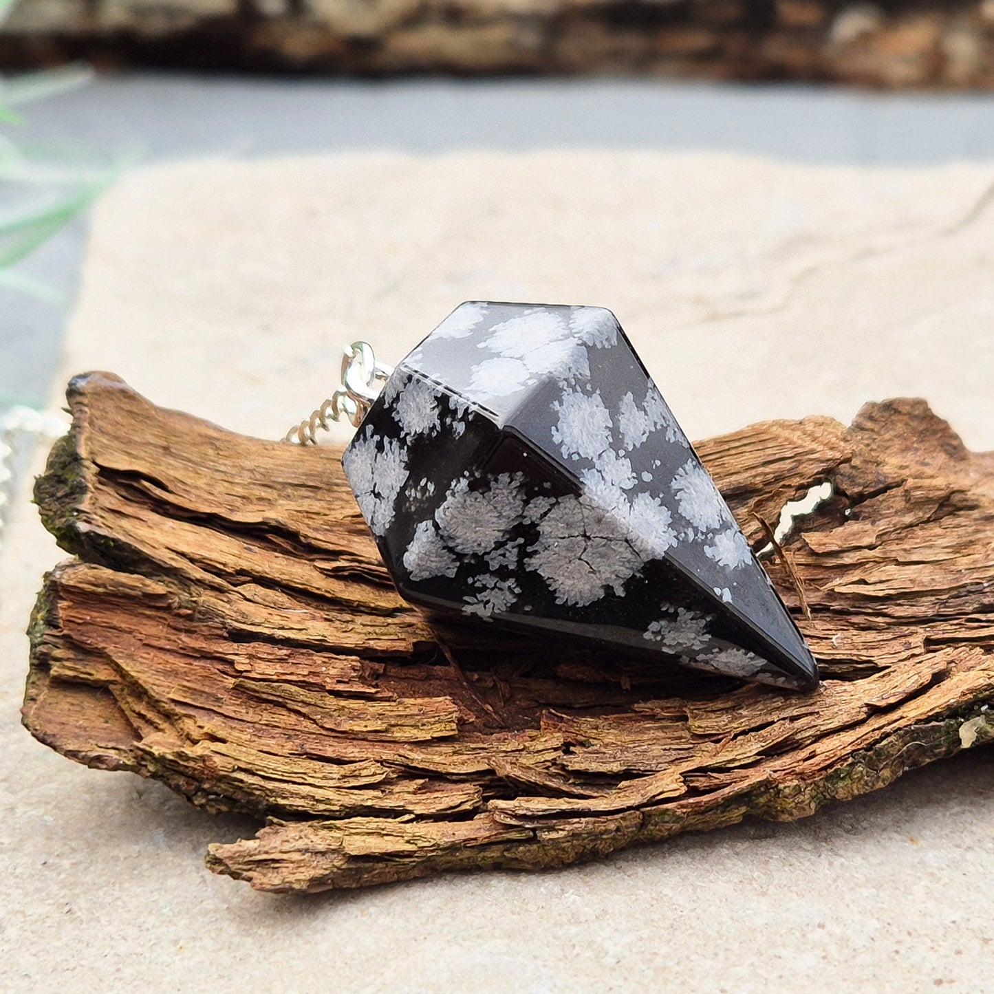 Snowflake Obsidian Crystal Pendulum from the USA. Comes in a organza pouch to keep it in. Chain has a metal ring at the end of it.