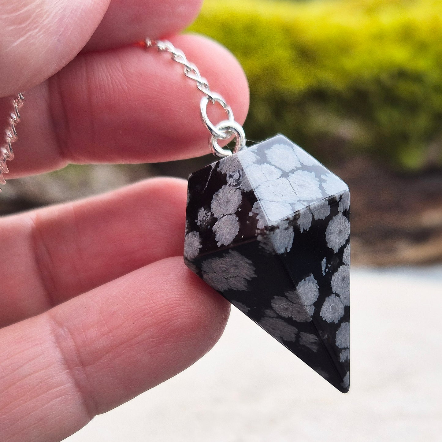 Snowflake Obsidian Crystal Pendulum from the USA. Comes in a organza pouch to keep it in. Chain has a metal ring at the end of it.
