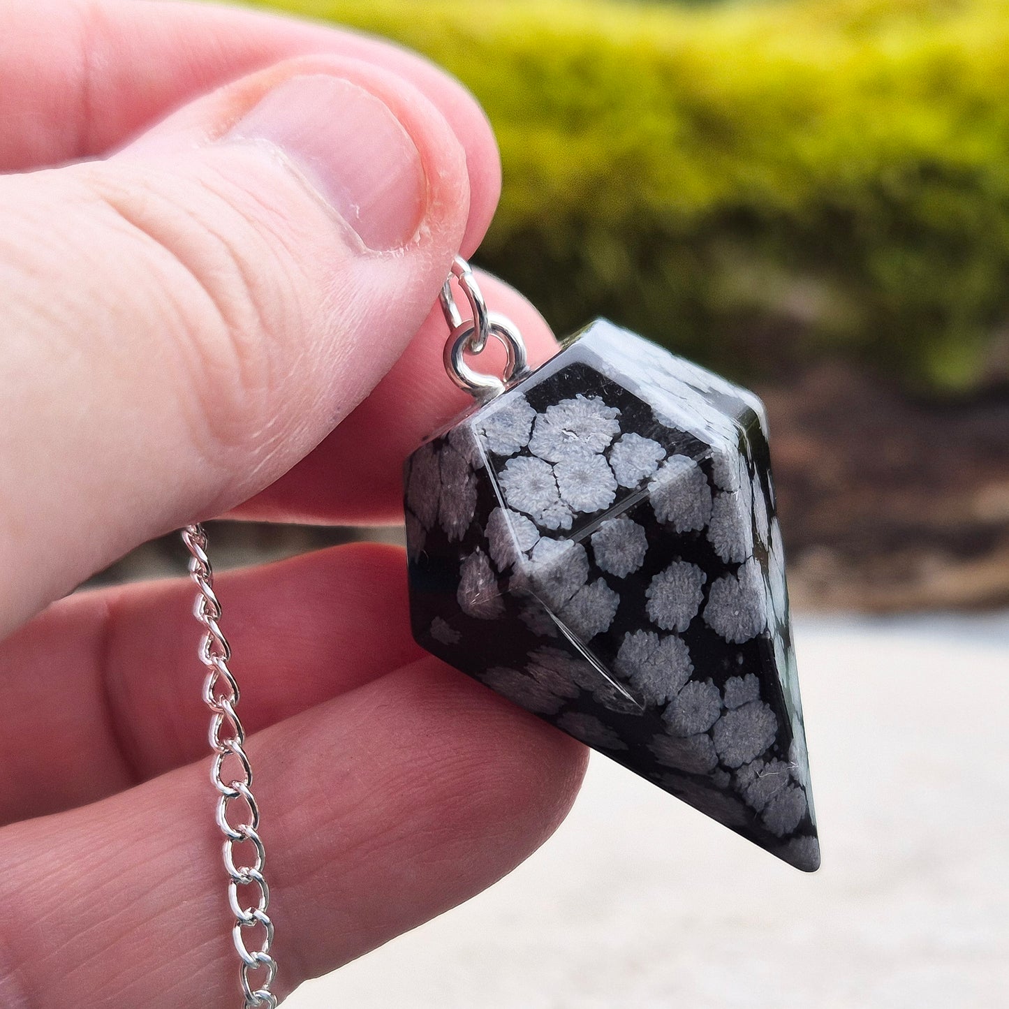 Snowflake Obsidian Crystal Pendulum from the USA. Comes in a organza pouch to keep it in. Chain has a metal ring at the end of it.