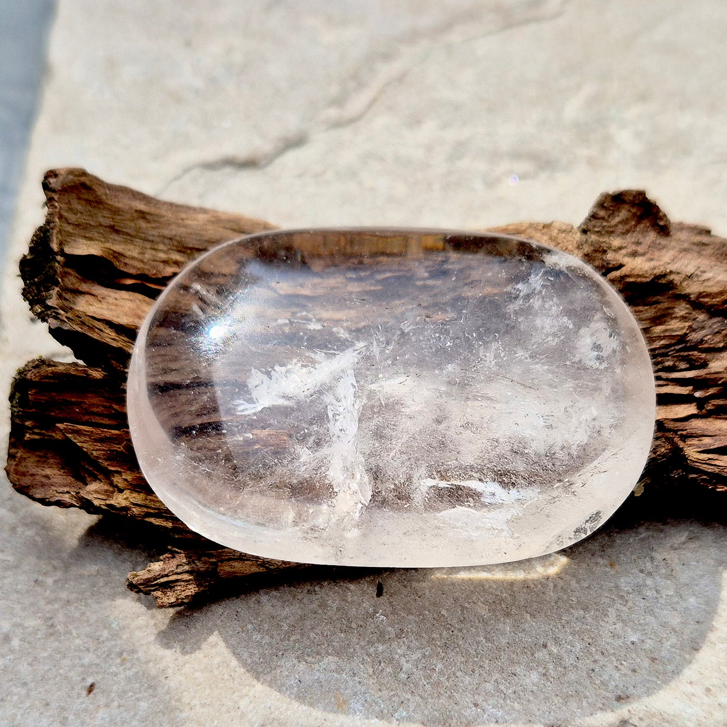 This beautifully polished Clear Quartz palm stone fits comfortably in the hand. Has light reflecting inclusions within it which catch the light.