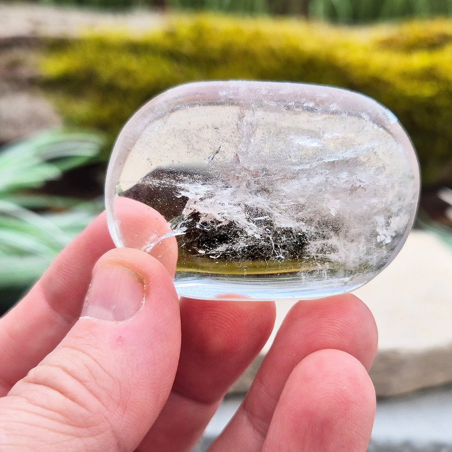 This beautifully polished Clear Quartz palm stone fits comfortably in the hand. Has light reflecting inclusions within it which catch the light.