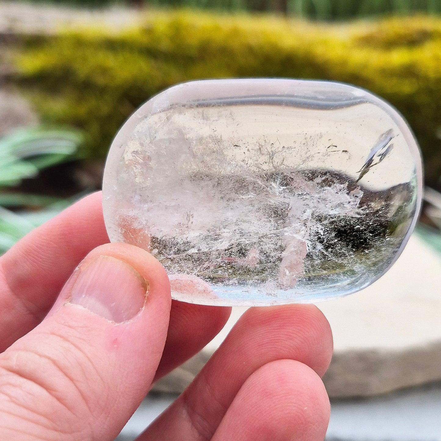 This beautifully polished Clear Quartz palm stone fits comfortably in the hand. Has light reflecting inclusions within it which catch the light.