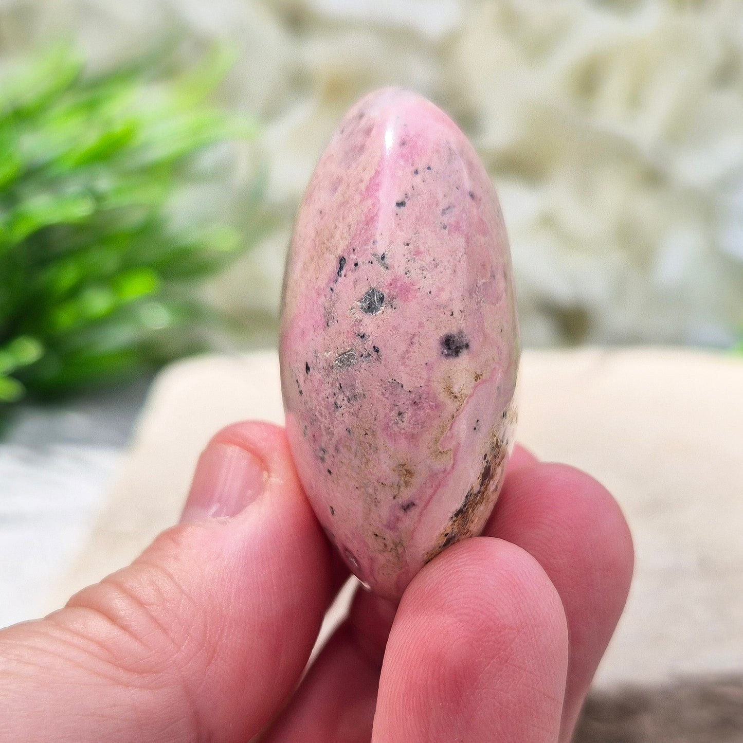 Pink Rhodonite Crystal Palm Stone – Also known as Bubblegum Pink Rhodonite from Peru
This soft pink Rhodonite, with natural black patches from manganese oxidation, is valued for its steady, reassuring energy.