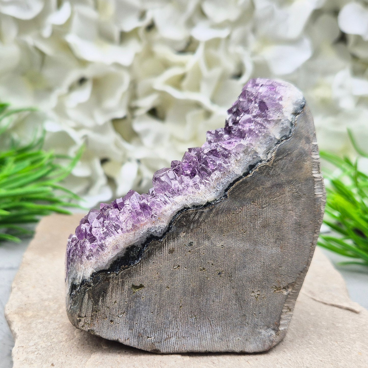 Amethyst Self-Standing Geode. This beautiful self-standing Amethyst Geode comes from Brazil. With its deep violet points and natural open-face formation, this piece offers both strength and serenity.