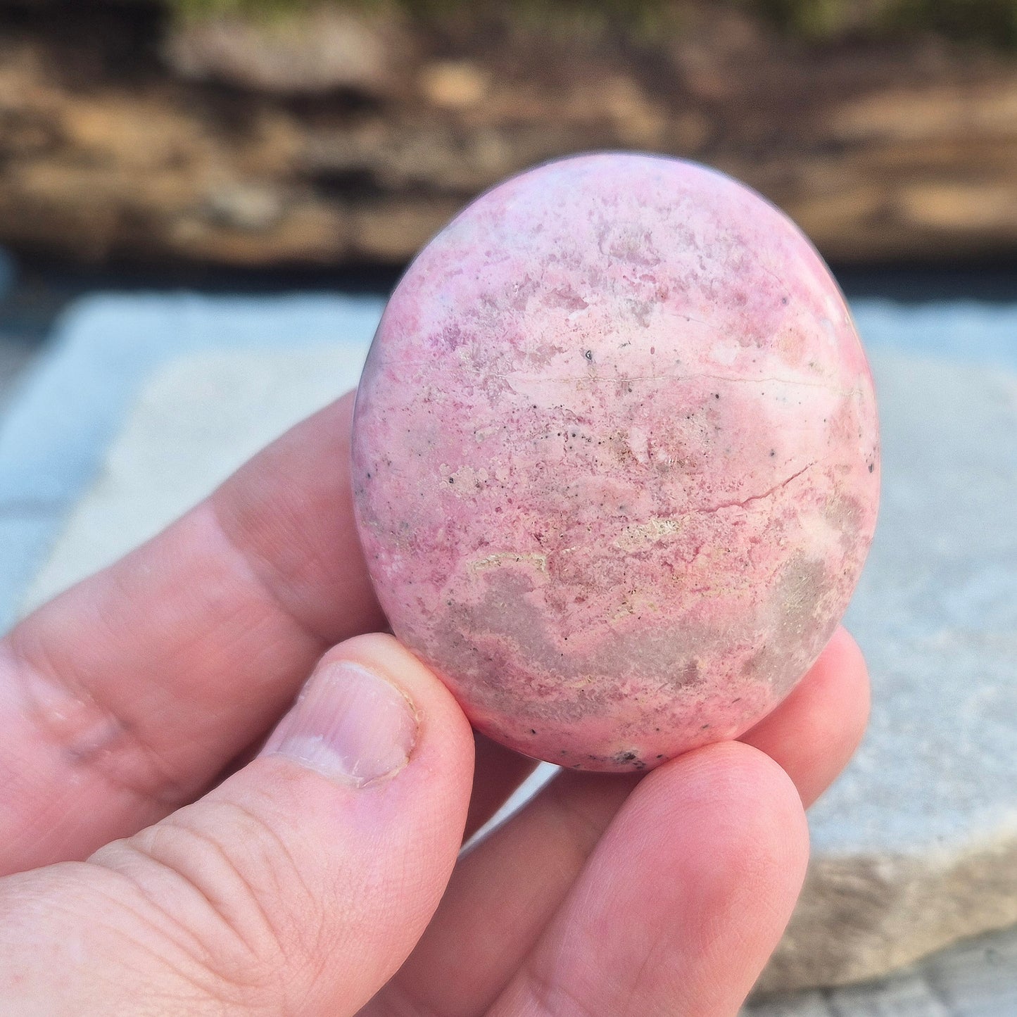 Pink Rhodonite Crystal Palm Stone – Also known as Bubblegum Pink Rhodonite from Peru. This soft pink Rhodonite, featuring natural black patches from manganese oxidation, is prized for its steady, reassuring energy.