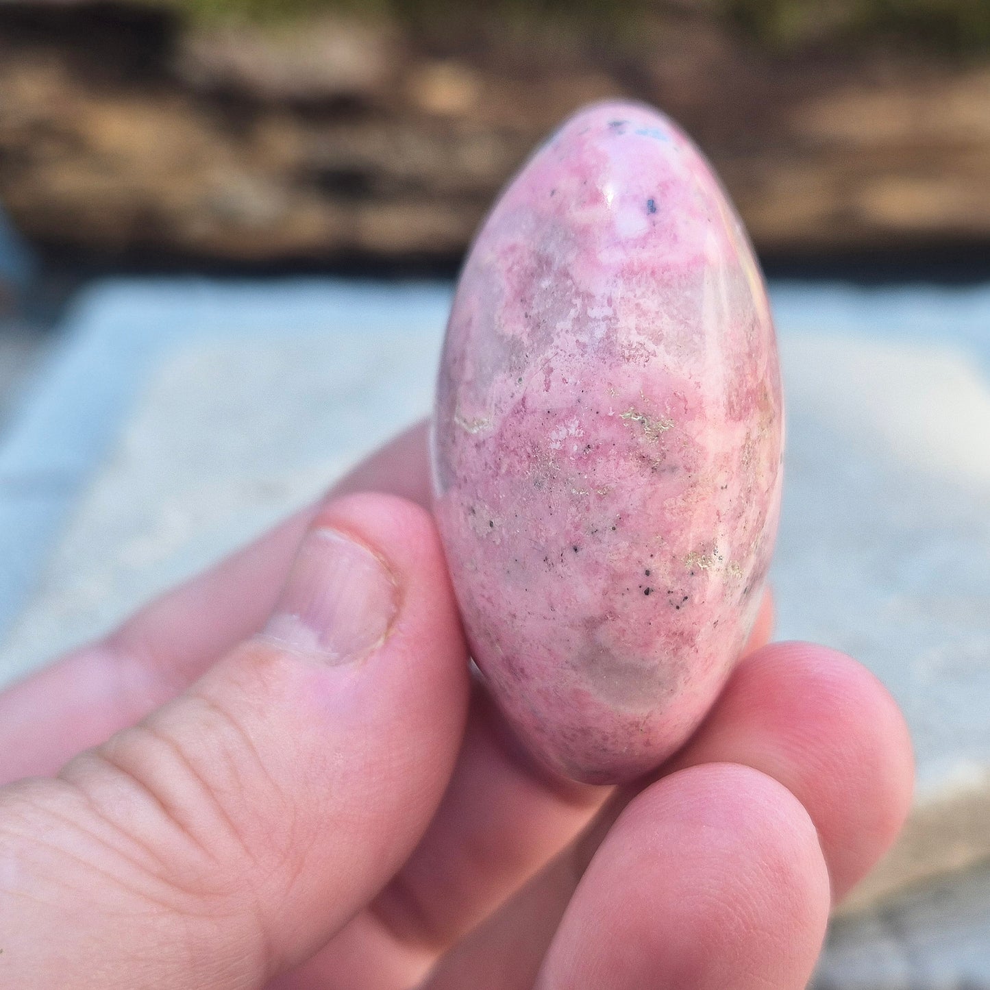 Pink Rhodonite Crystal Palm Stone – Also known as Bubblegum Pink Rhodonite from Peru. This soft pink Rhodonite, featuring natural black patches from manganese oxidation, is prized for its steady, reassuring energy.