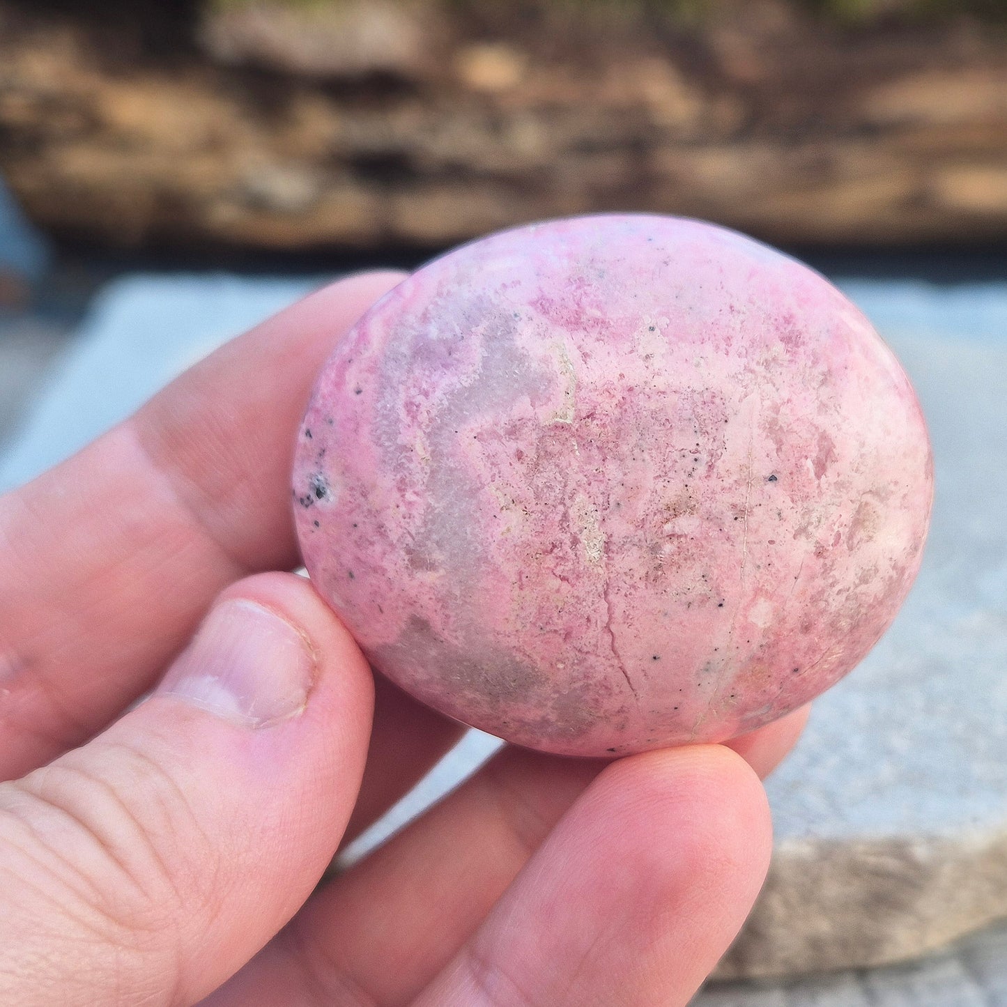 Pink Rhodonite Crystal Palm Stone – Also known as Bubblegum Pink Rhodonite from Peru. This soft pink Rhodonite, featuring natural black patches from manganese oxidation, is prized for its steady, reassuring energy.