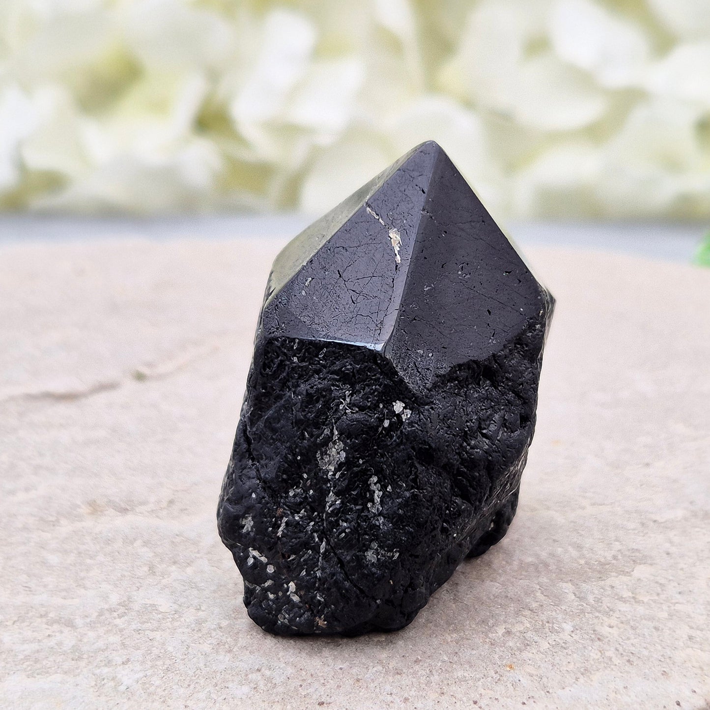 Black Tourmaline point from Brazil, which has polished tip, natural sides and cut flatbase. Contains a few sparkly Mica inclusions. A perfect piece for anyone needing strong protection, energetic clarity, and emotional strength.