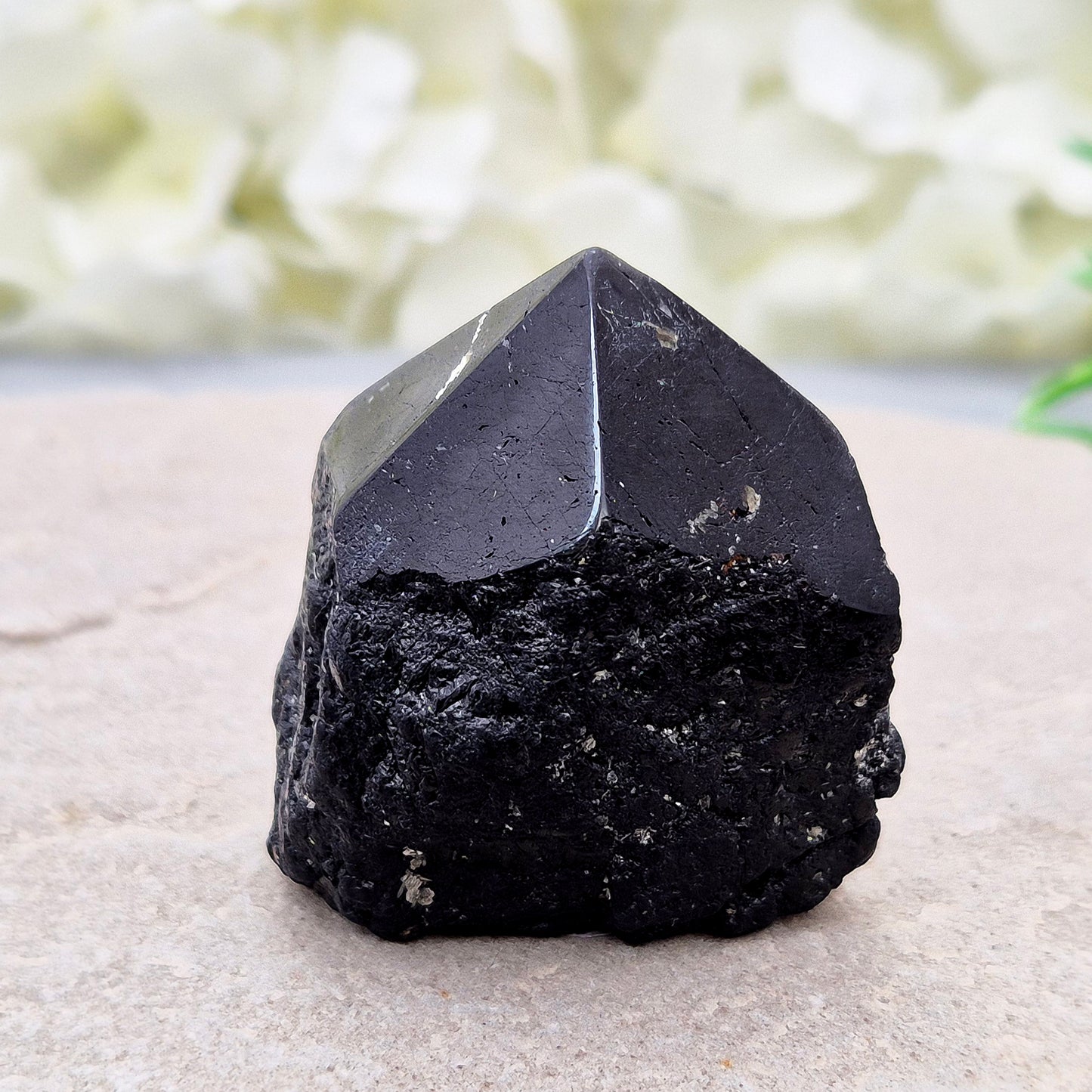 Black Tourmaline point from Brazil, which has polished tip, natural sides and cut flatbase. Contains a few sparkly Mica inclusions. A perfect piece for anyone needing strong protection, energetic clarity, and emotional strength.
