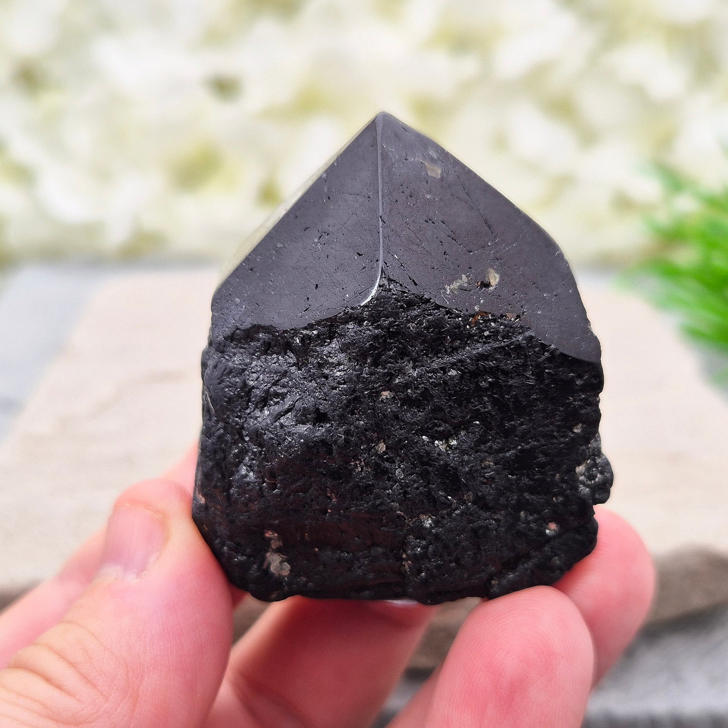 Black Tourmaline point from Brazil, which has polished tip, natural sides and cut flatbase. Contains a few sparkly Mica inclusions. A perfect piece for anyone needing strong protection, energetic clarity, and emotional strength.
