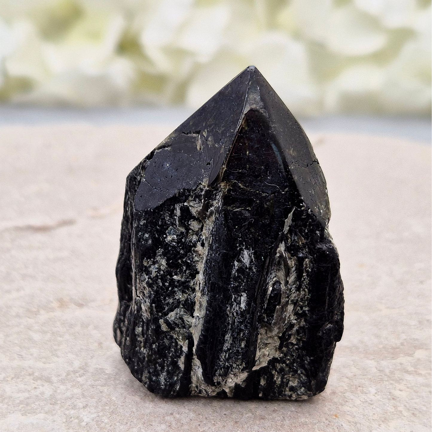 Black Tourmaline point from Brazil, which has polished tip, natural sides and cut flatbase. Contains quite a few sparkly Mica inclusions. A perfect piece for anyone needing strong protection, energetic clarity, and emotional strength.
