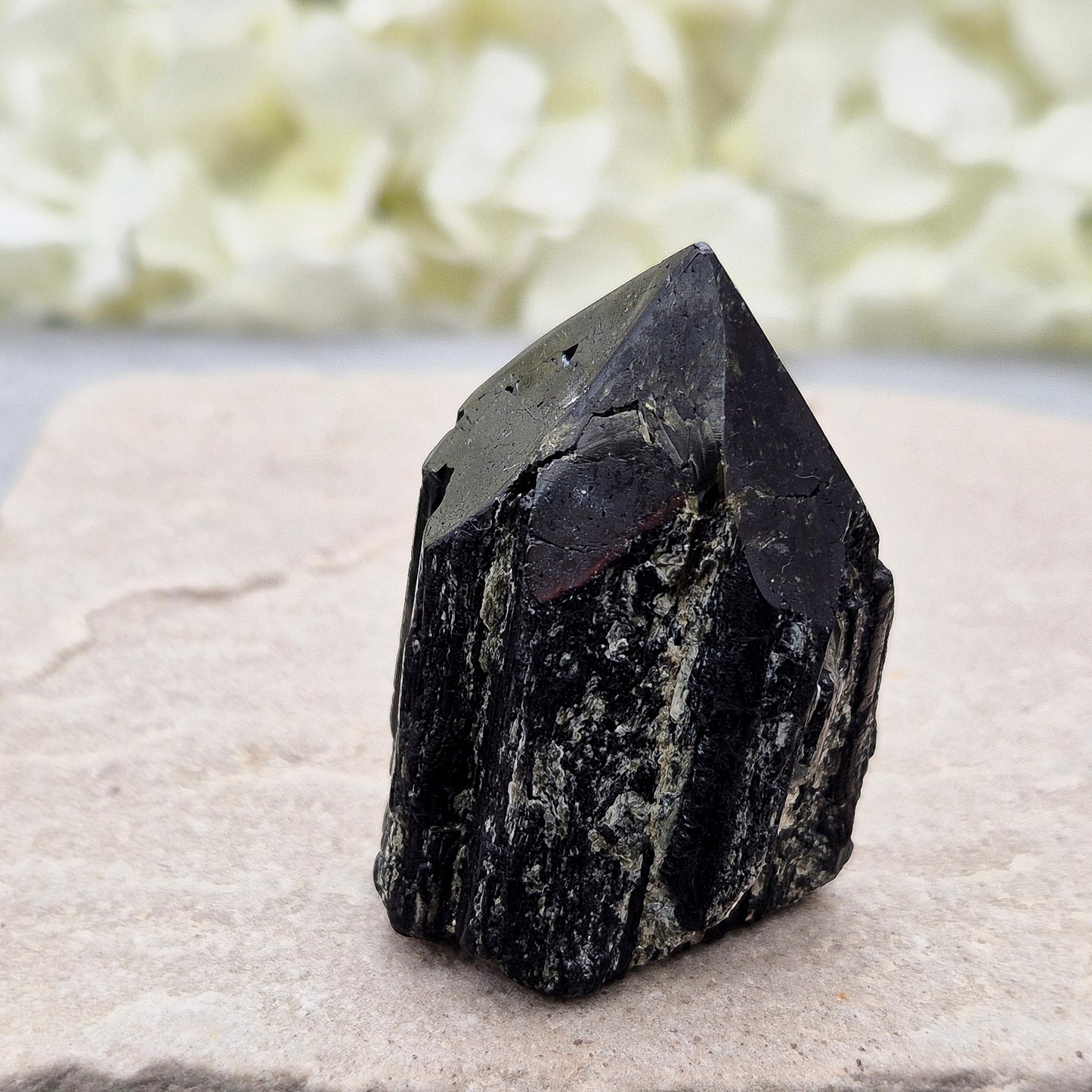 Black Tourmaline point from Brazil, which has polished tip, natural sides and cut flatbase. Contains quite a few sparkly Mica inclusions. A perfect piece for anyone needing strong protection, energetic clarity, and emotional strength.