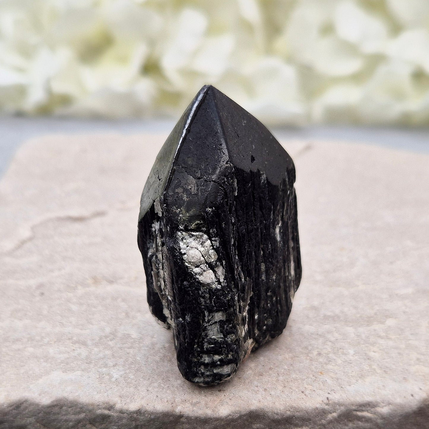 Black Tourmaline point from Brazil, which has polished tip, natural sides and cut flatbase. Contains quite a few sparkly Mica inclusions. A perfect piece for anyone needing strong protection, energetic clarity, and emotional strength.
