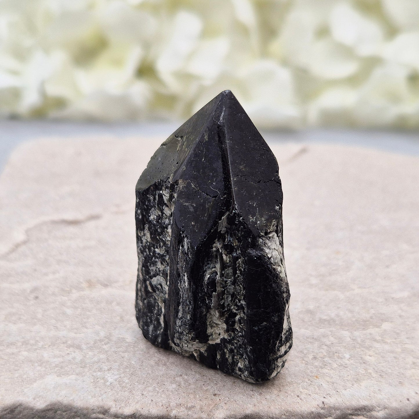 Black Tourmaline point from Brazil, which has polished tip, natural sides and cut flatbase. Contains quite a few sparkly Mica inclusions. A perfect piece for anyone needing strong protection, energetic clarity, and emotional strength.