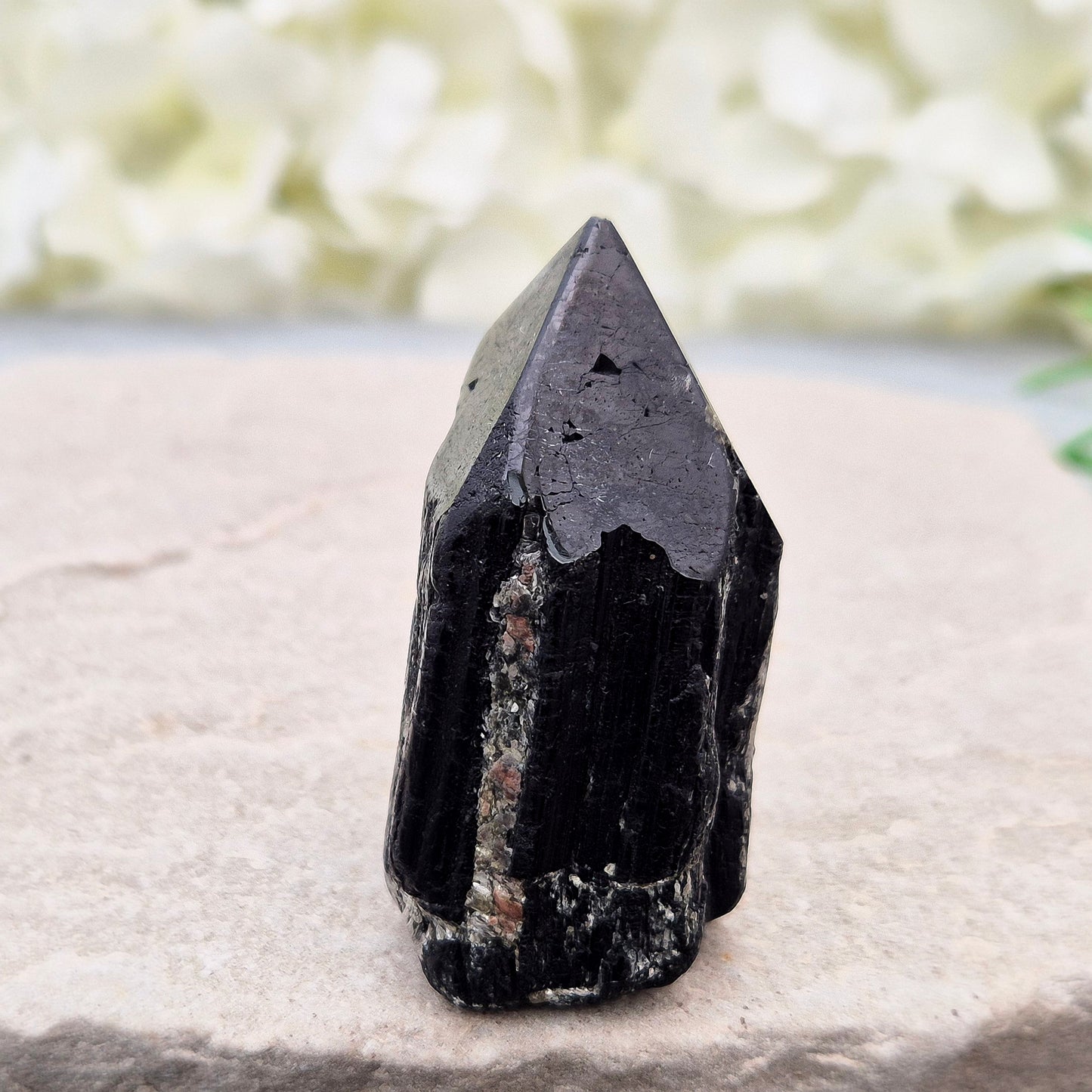 Black Tourmaline point from Brazil, which has polished tip, natural sides and cut flatbase. Contains quite a few sparkly Mica inclusions. A perfect piece for anyone needing strong protection, energetic clarity, and emotional strength.
