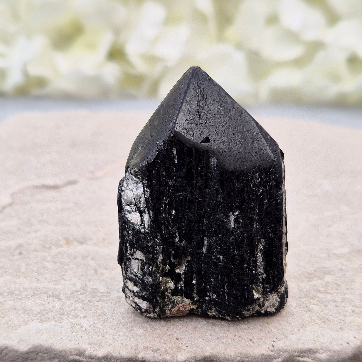 Black Tourmaline point from Brazil, which has polished tip, natural sides and cut flatbase. Contains quite a few sparkly Mica inclusions. A perfect piece for anyone needing strong protection, energetic clarity, and emotional strength.