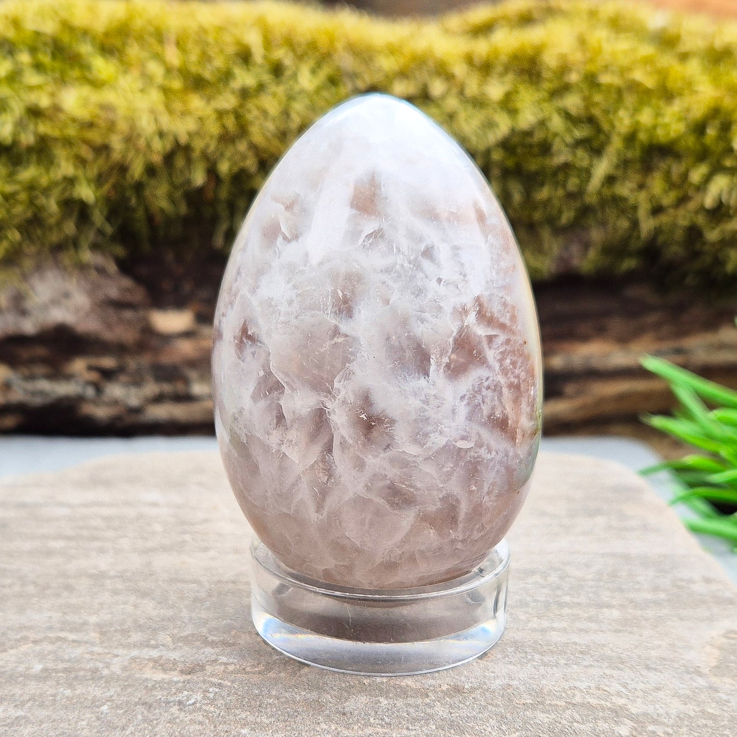 This beautiful Druzy Agate egg from Brazil is polished and showcases a sparkling pocket of natural druzy crystals in the middle of it. It comes with a clear acrylic stand, making it a lovely addition to any space or crystal shelf. Its soft, steady energy brings emotional calm, grounding, and quiet strength.