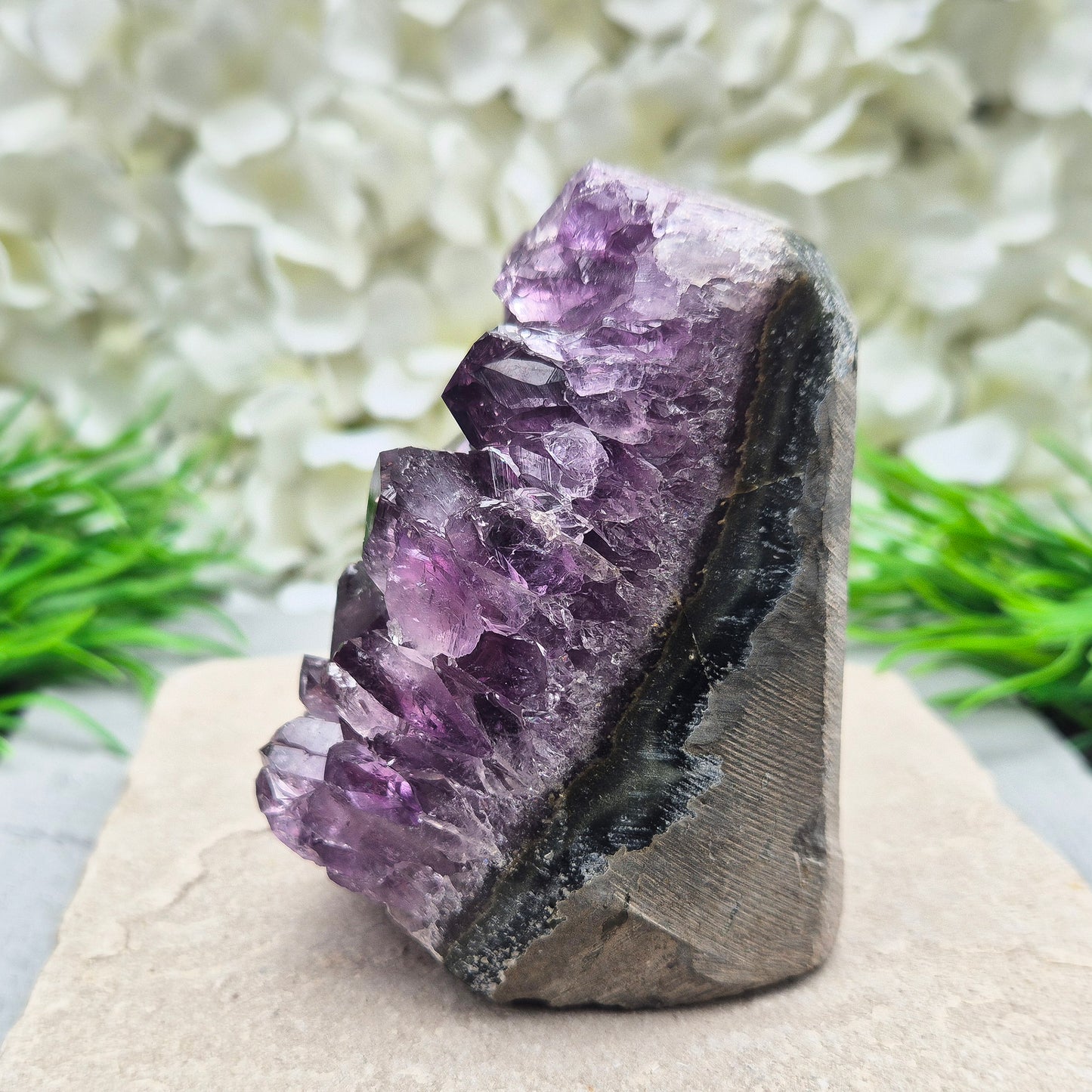 This beautiful self-standing Amethyst Geode from Brazil features lovely deep purple points and a natural open-face formation. Its deep colour and solid structure bring both visual beauty and a quiet strength to any space.
