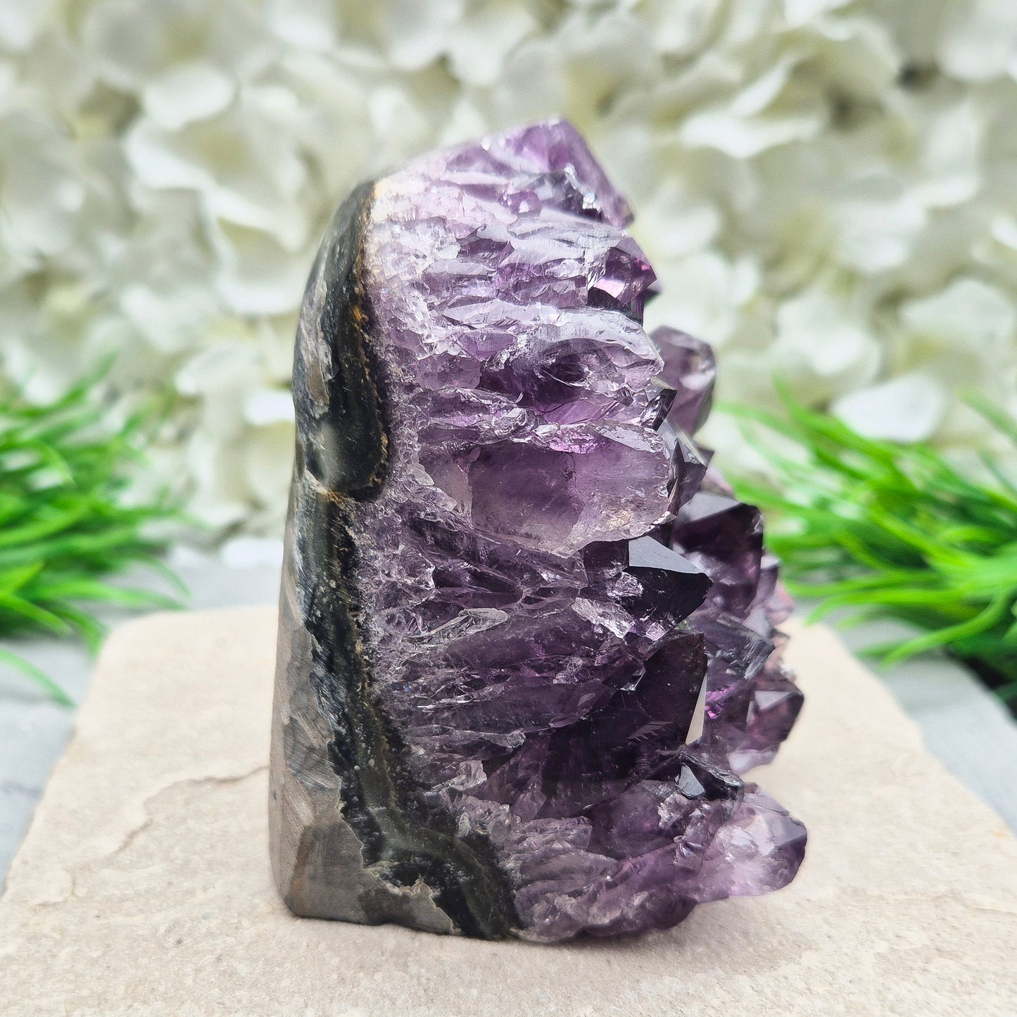 This beautiful self-standing Amethyst Geode from Brazil features lovely deep purple points and a natural open-face formation. Its deep colour and solid structure bring both visual beauty and a quiet strength to any space.