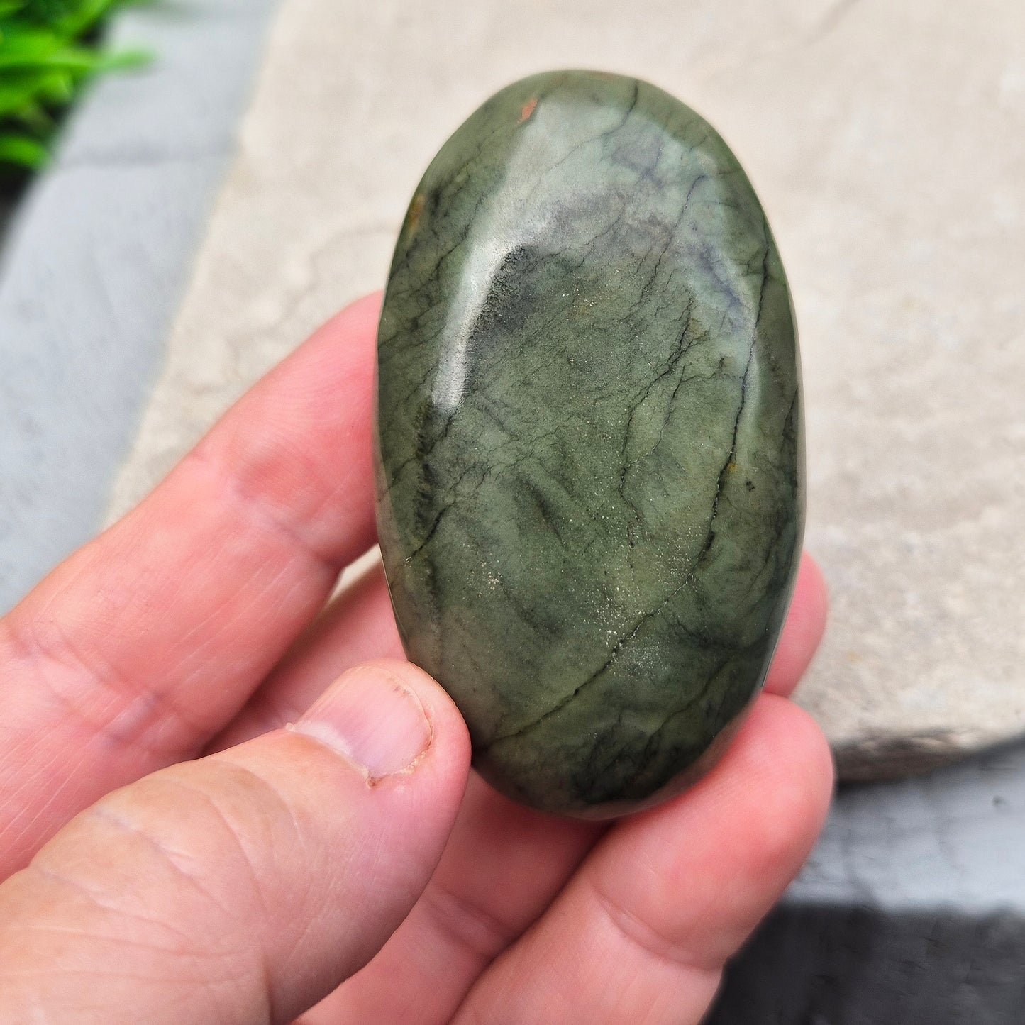 This smooth, polished Nephrite Jade palm stone from Pakistan features classic deep green tones. Nephrite Jade has long been seen as a stone of luck and wellbeing — but it's also a true ally for emotional balance and inner strength. T