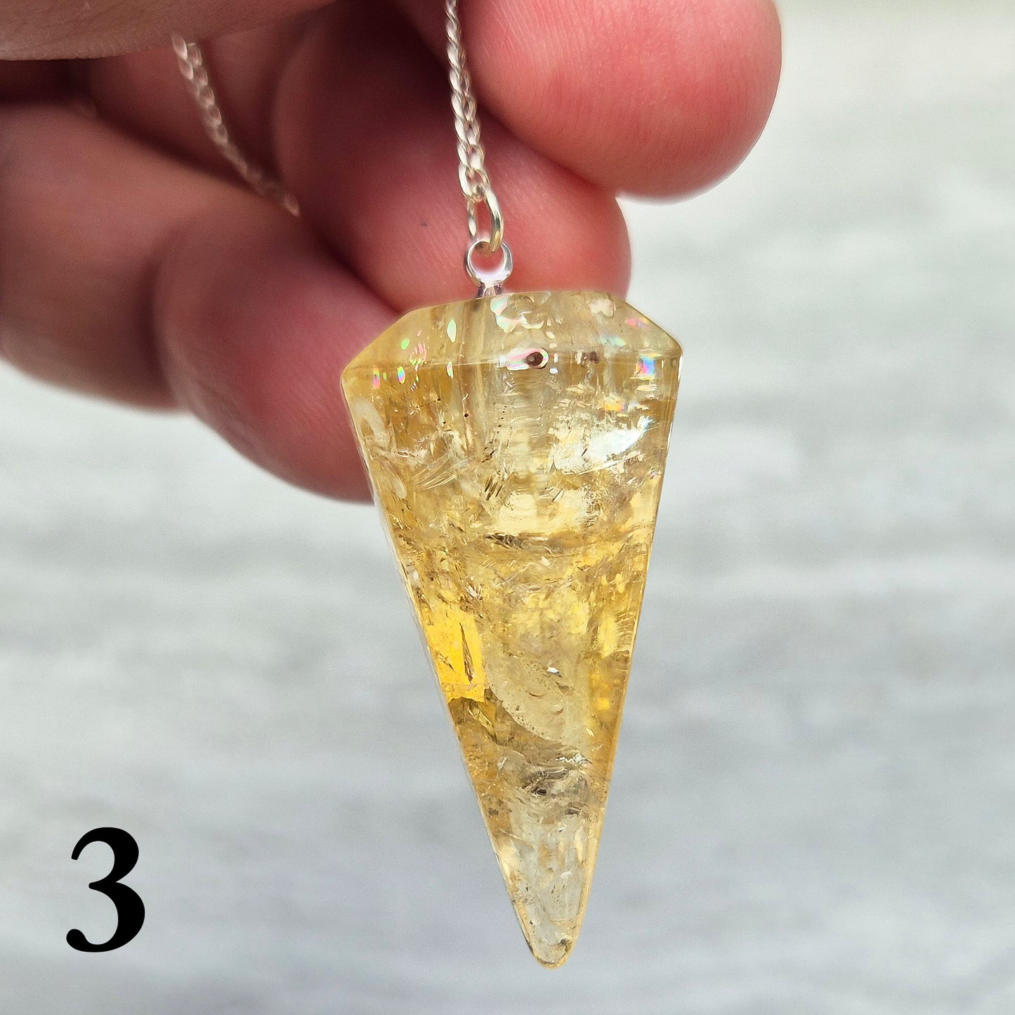 Citrine Crystal Pendulum from Brazil. These stunning sunny pendulums carry the warm, golden glow Citrine is loved for. Each has a yellow bead at the end of the chain making it comfortable to hold and easy to use.