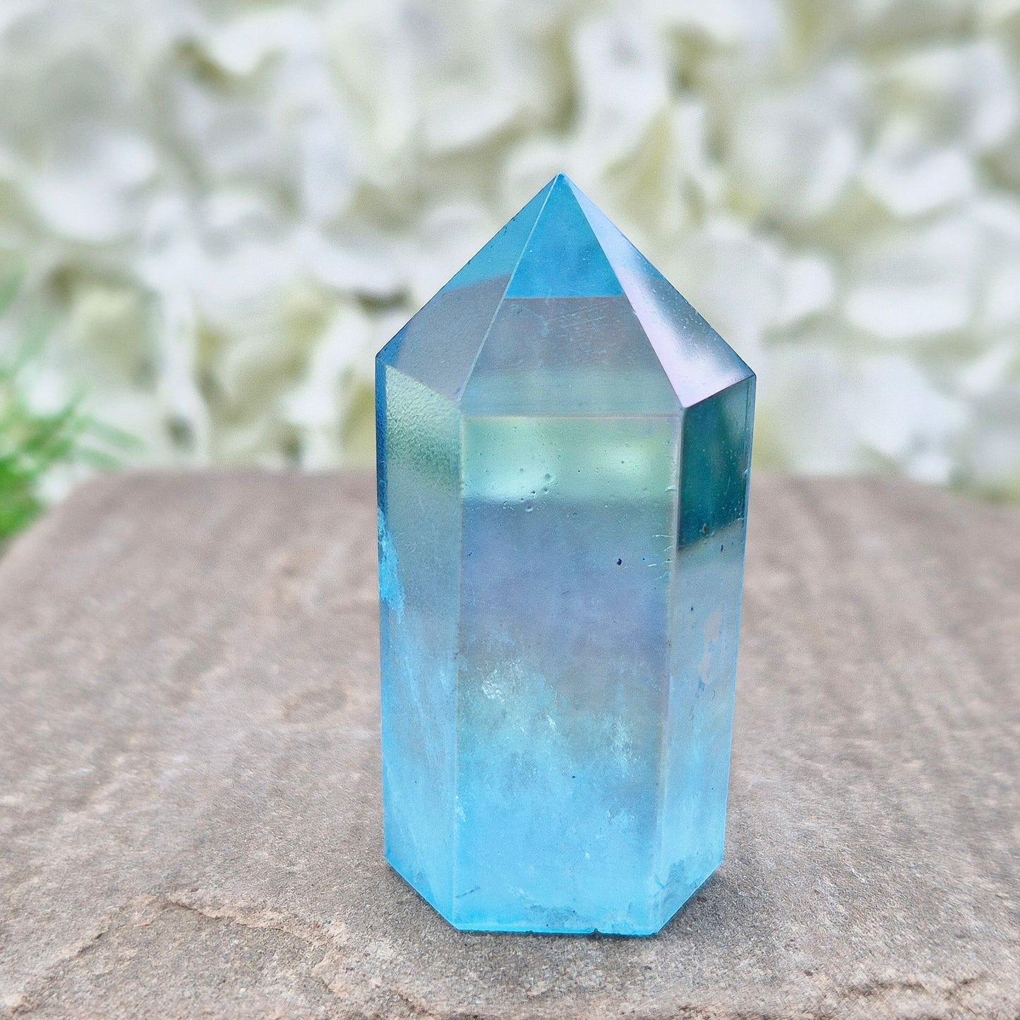 This beautiful Aqua Aura Quartz Standing Point from Brazil has an electric blue sheen with soft rainbow flashes, created by bonding pure gold to Quartz in a special heat process. The result is a striking crystal with a bright, peaceful energy.