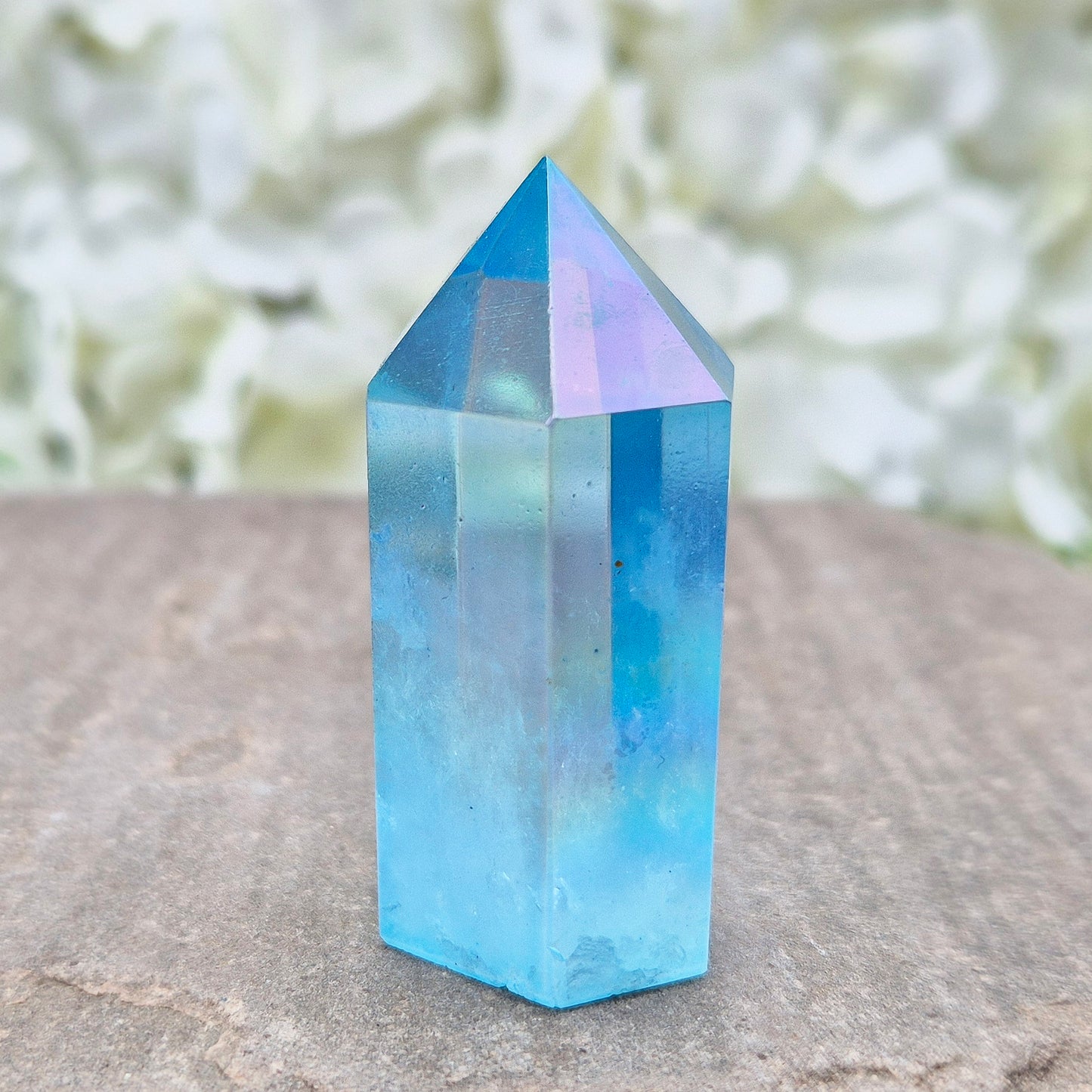 This beautiful Aqua Aura Quartz Standing Point from Brazil has an electric blue sheen with soft rainbow flashes, created by bonding pure gold to Quartz in a special heat process. The result is a striking crystal with a bright, peaceful energy.