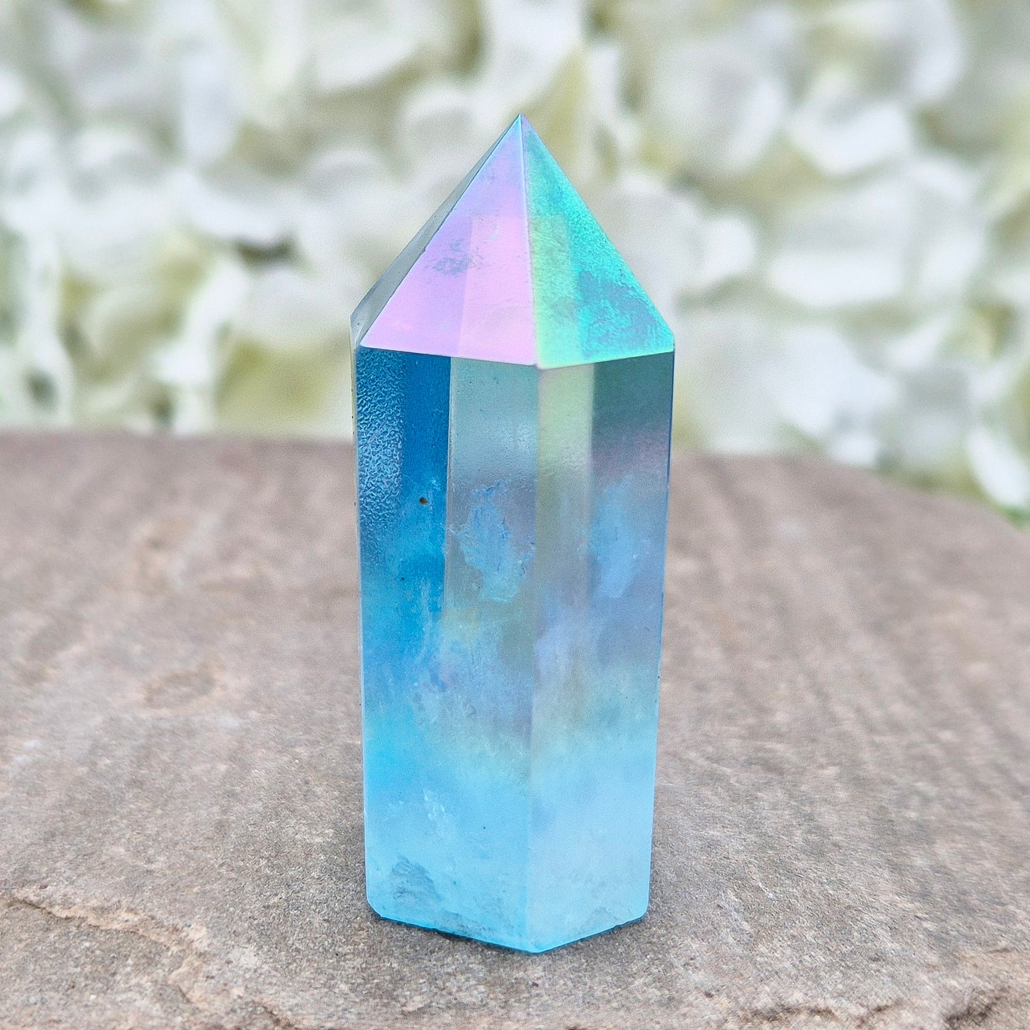 This beautiful Aqua Aura Quartz Standing Point from Brazil has an electric blue sheen with soft rainbow flashes, created by bonding pure gold to Quartz in a special heat process. The result is a striking crystal with a bright, peaceful energy.