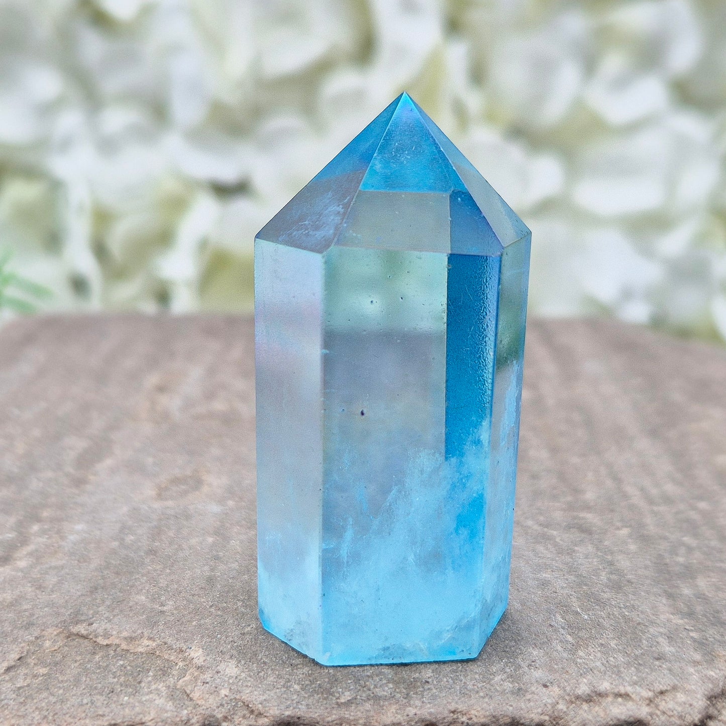 This beautiful Aqua Aura Quartz Standing Point from Brazil has an electric blue sheen with soft rainbow flashes, created by bonding pure gold to Quartz in a special heat process. The result is a striking crystal with a bright, peaceful energy.
