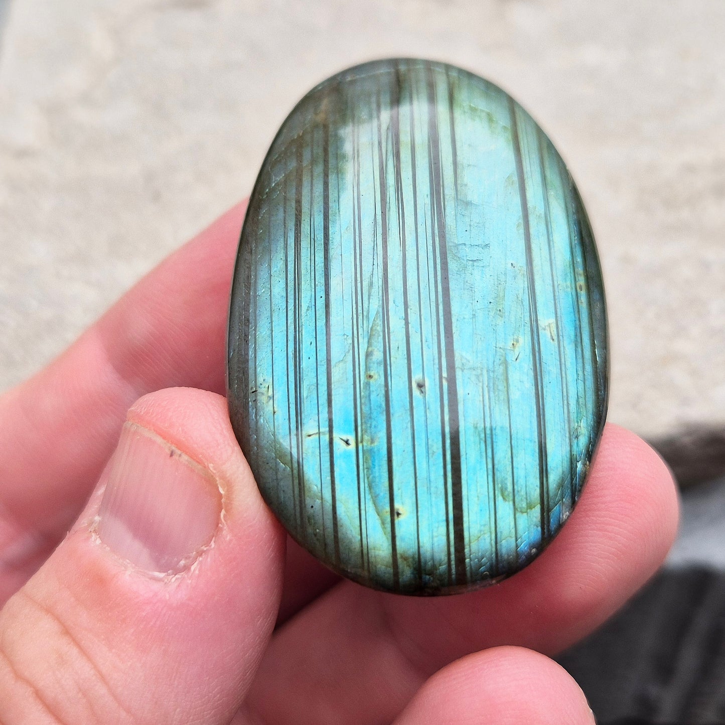 This Labradorite palm stone catches the light with a stunning array of flashes of blue/green.
