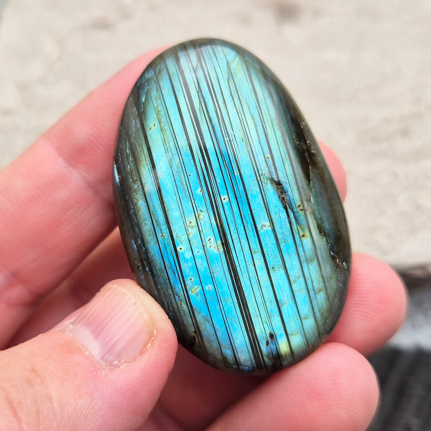 This Labradorite palm stone catches the light with a stunning array of flashes of blue/green.