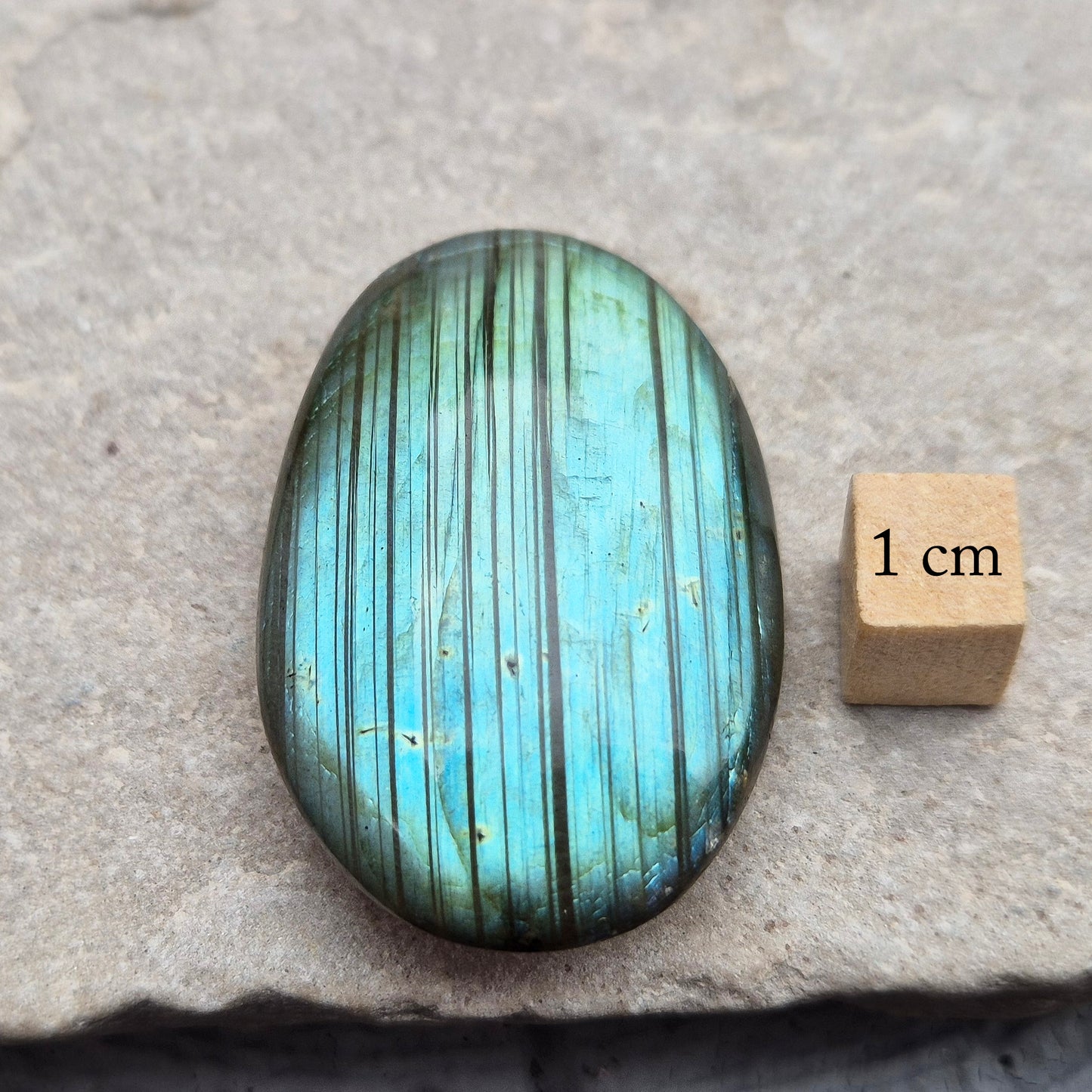 This Labradorite palm stone catches the light with a stunning array of flashes of blue/green.