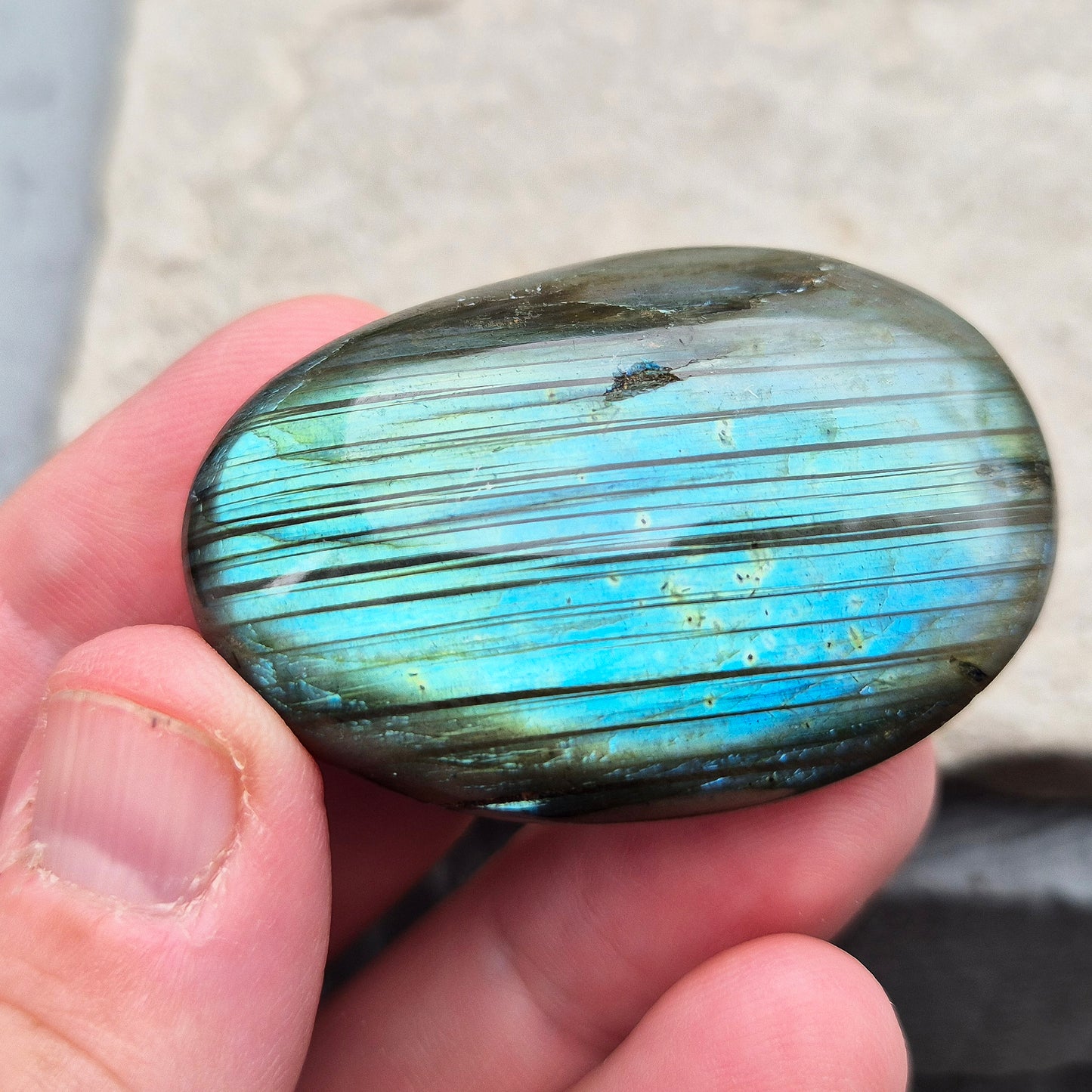 This Labradorite palm stone catches the light with a stunning array of flashes of blue/green.