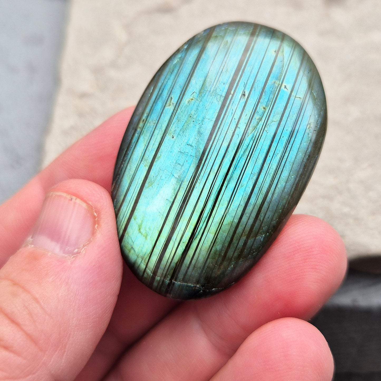 This Labradorite palm stone catches the light with a stunning array of flashes of blue/green.