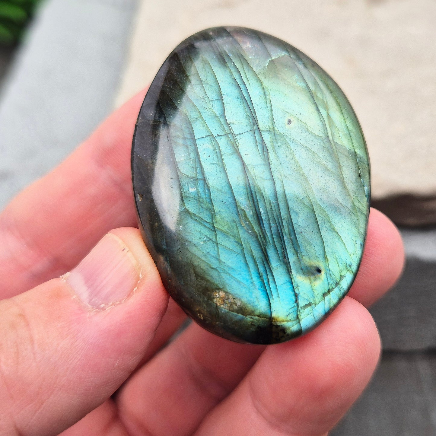 This Labradorite palm stone catches the light with a stunning array of flashes of blue/green.