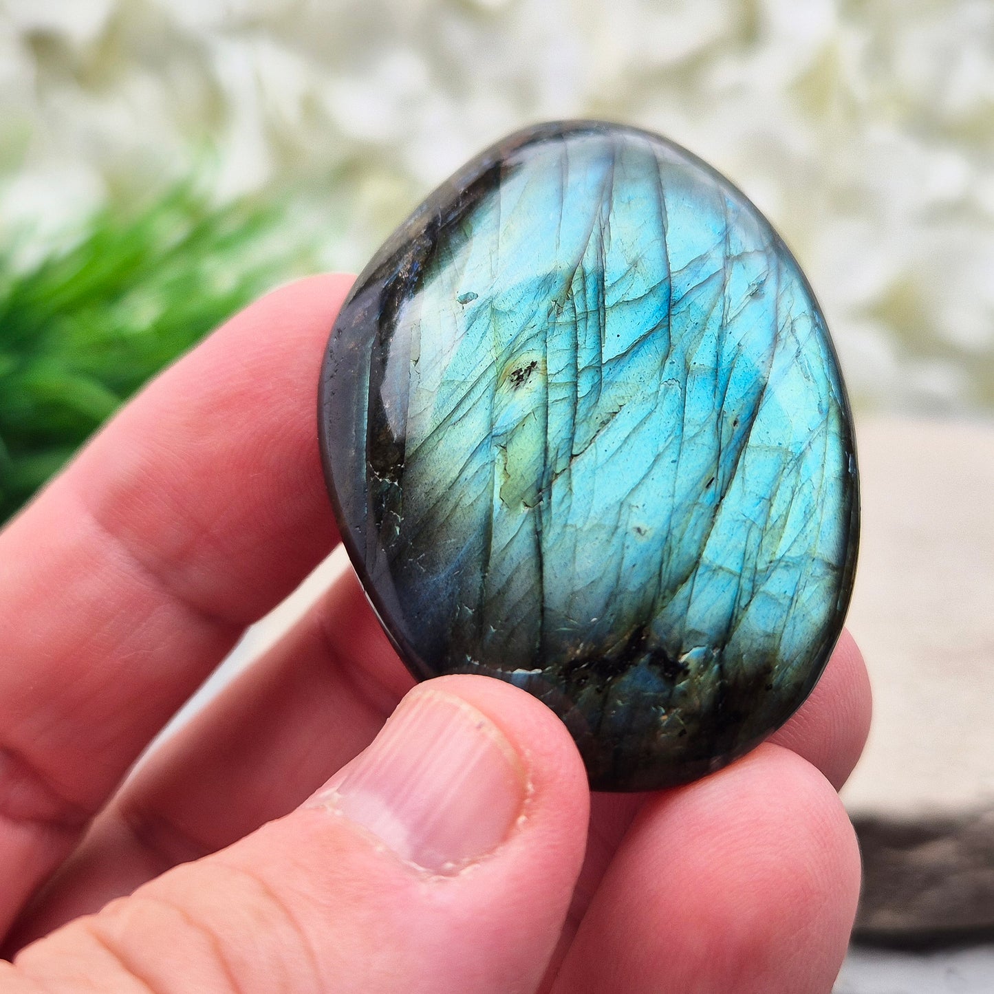 This Labradorite palm stone catches the light with a stunning array of flashes of blue/green.