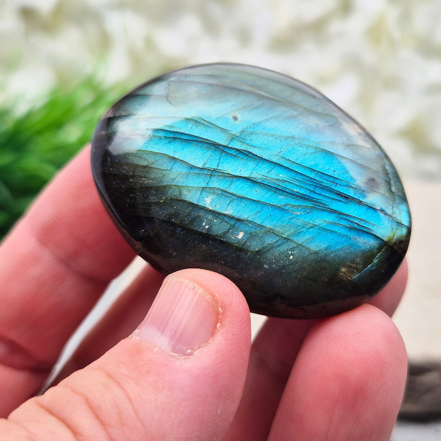 This Labradorite palm stone catches the light with a stunning array of flashes of blue/green.