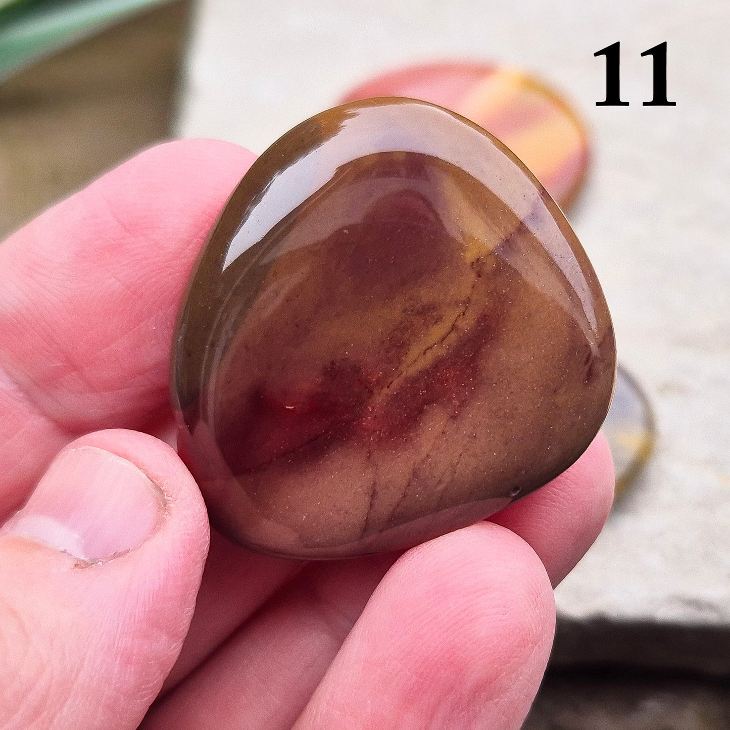 Mookaite Crystal Palm Stone. From the Mooka Creek region in Western Australia, each Mookaite palm stone displays a unique mix of earthy tones—reds, yellows, creams, and purples.