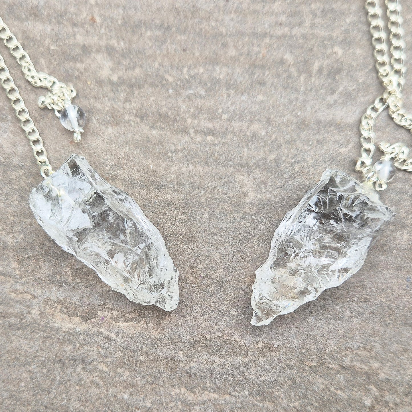 This Rock Quartz Crystal Pendulum from Brazil features a natural quartz crystal and a white bead at the end of the chain.