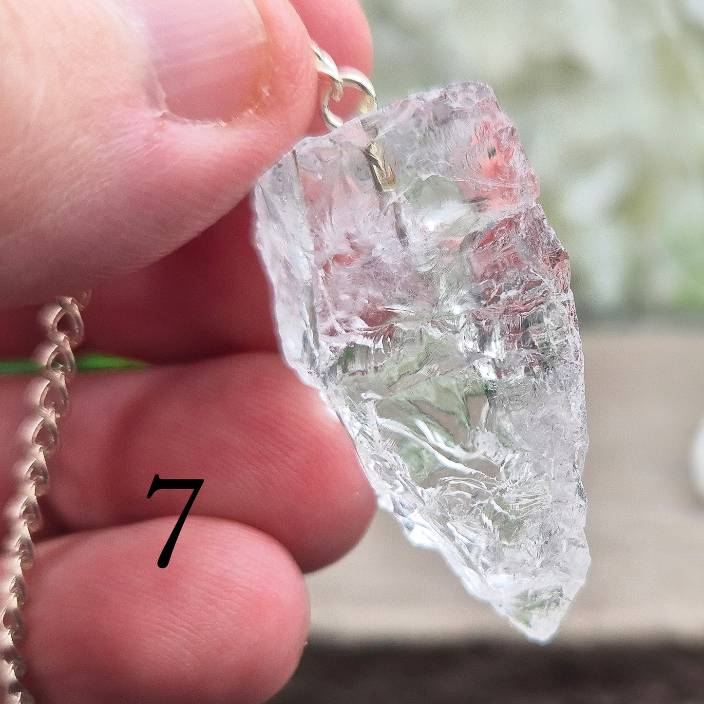 This Rock Quartz Crystal Pendulum from Brazil features a natural quartz crystal and a white bead at the end of the chain.